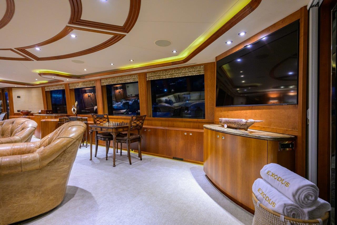 a living room with a wood cabinet aboard EXODUS Yacht for Sale