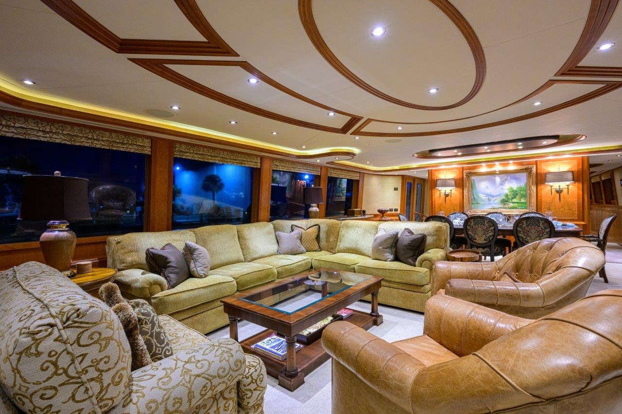 a living room with a large chandelier aboard EXODUS Yacht for Sale