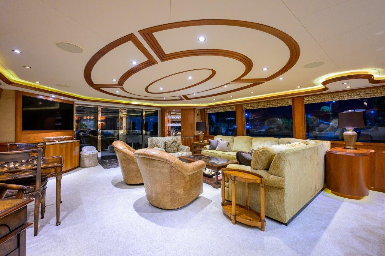 a living room with a large chandelier aboard EXODUS Yacht for Sale