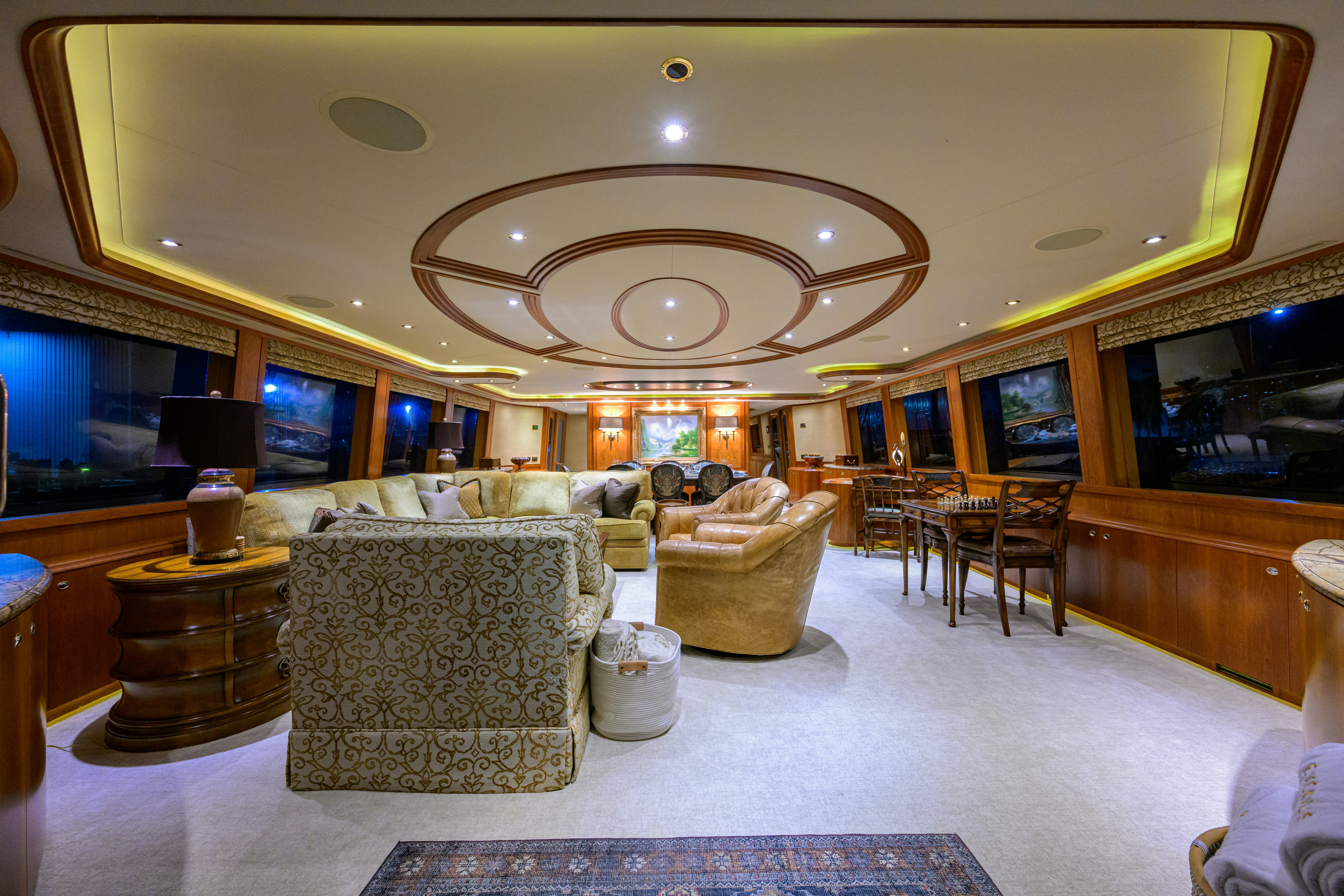 a living room with a chandelier aboard EXODUS Yacht for Sale