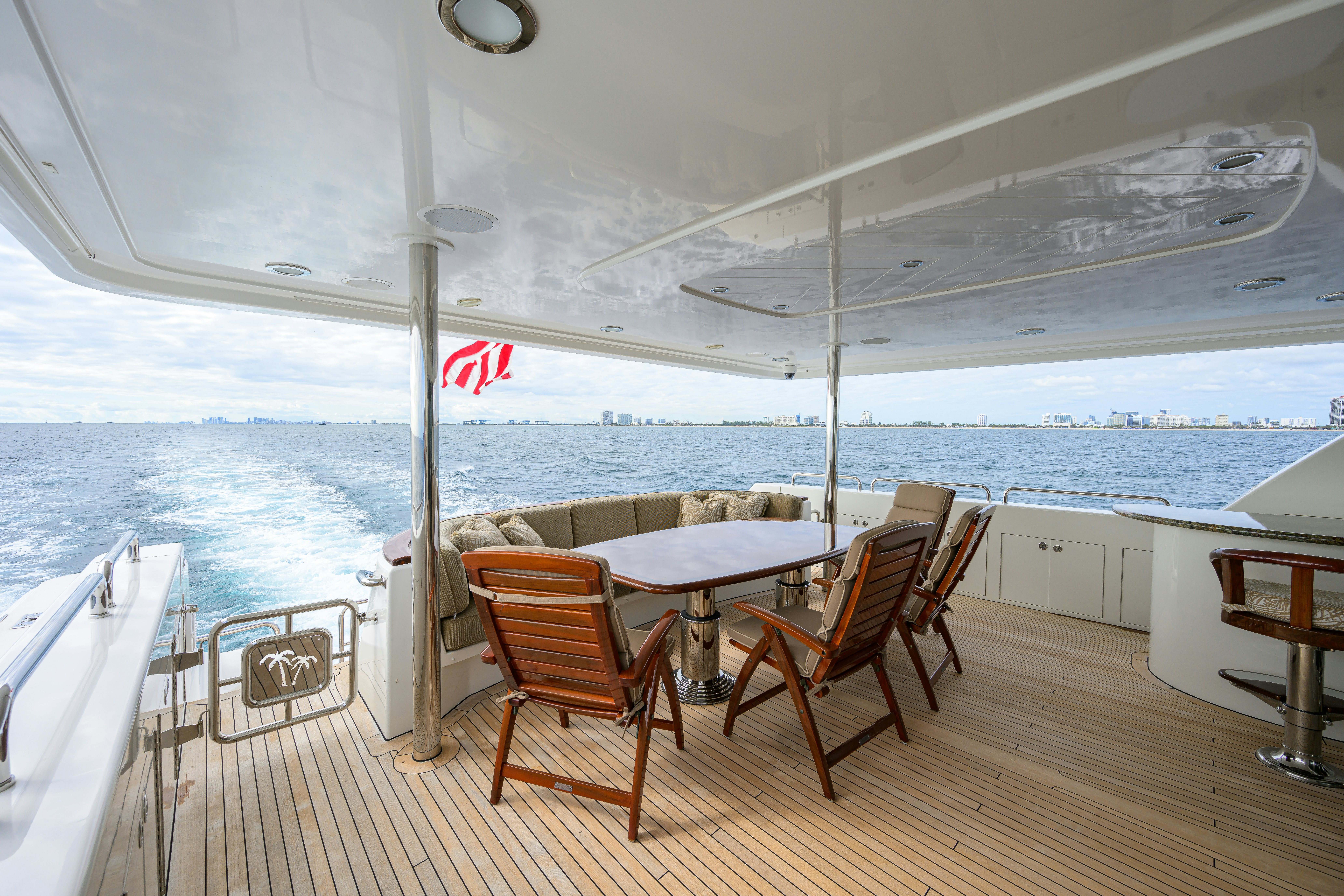 a deck with a table and chairs on it aboard EXODUS Yacht for Sale