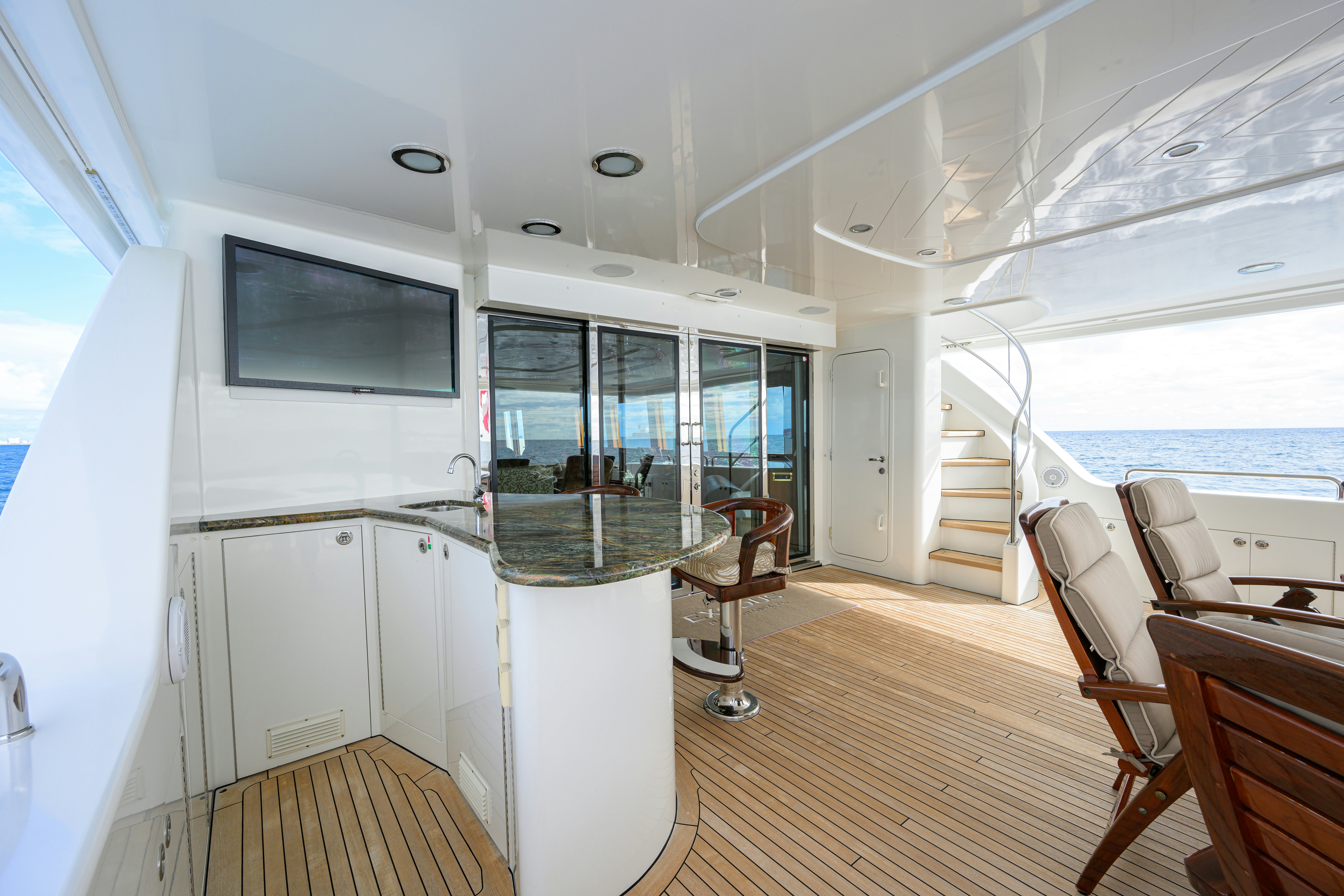 a room with a large window and a table and chairs aboard EXODUS Yacht for Sale