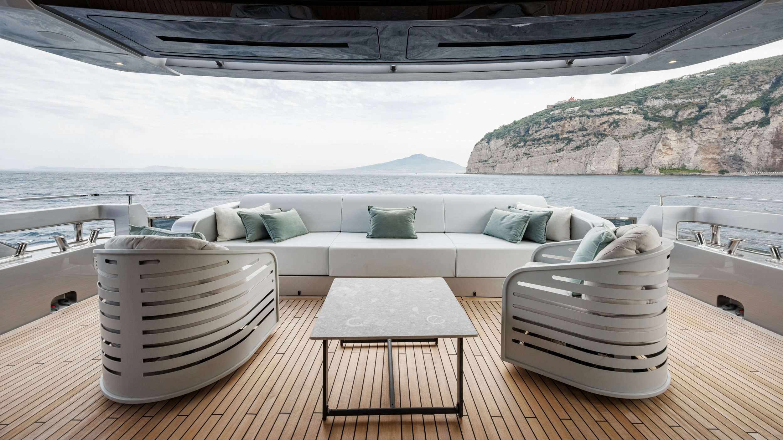 a white couch and chairs on a deck overlooking a large body of water aboard STILE DI VITA Yacht for Sale