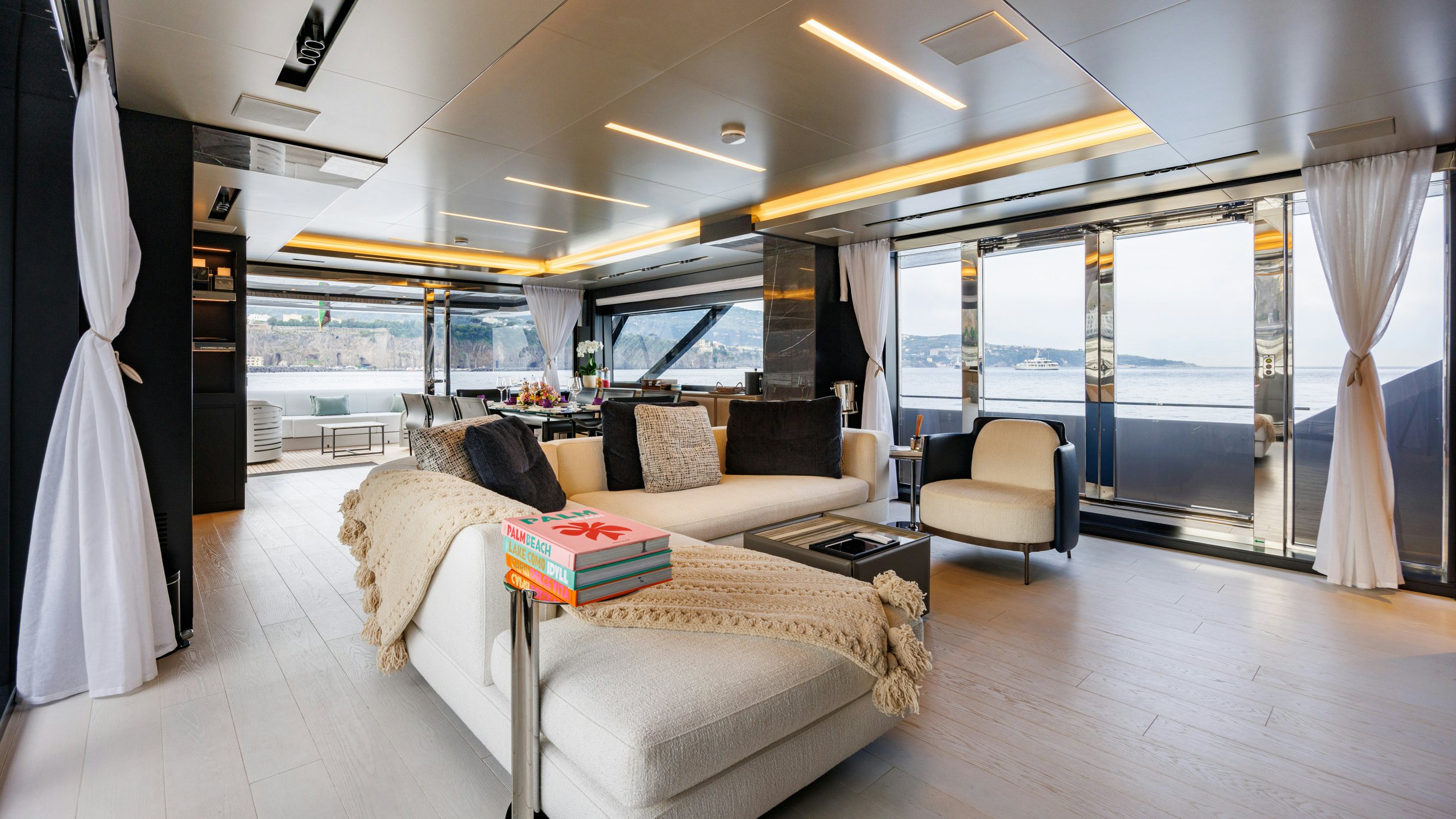 a room with a couch and a table and a large window aboard STILE DI VITA Yacht for Sale