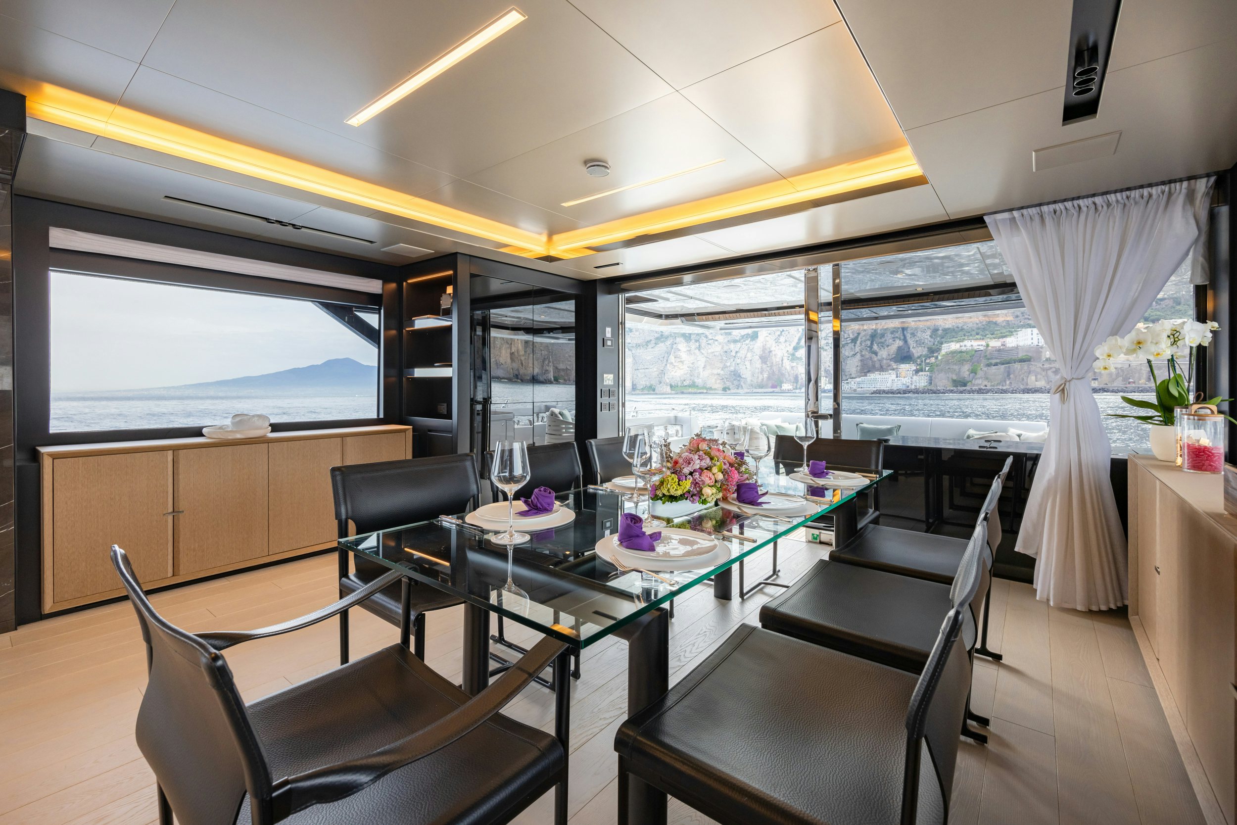 a room with a table chairs and a window aboard STILE DI VITA Yacht for Sale