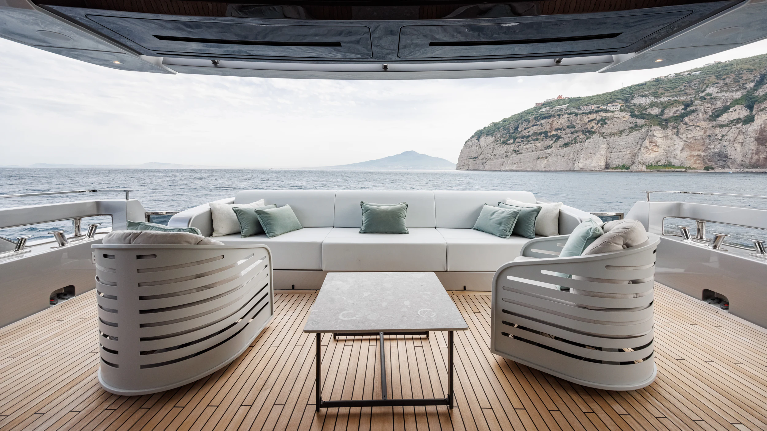 a white couch and chairs on a deck overlooking a large body of water aboard STILE DI VITA Yacht for Charter