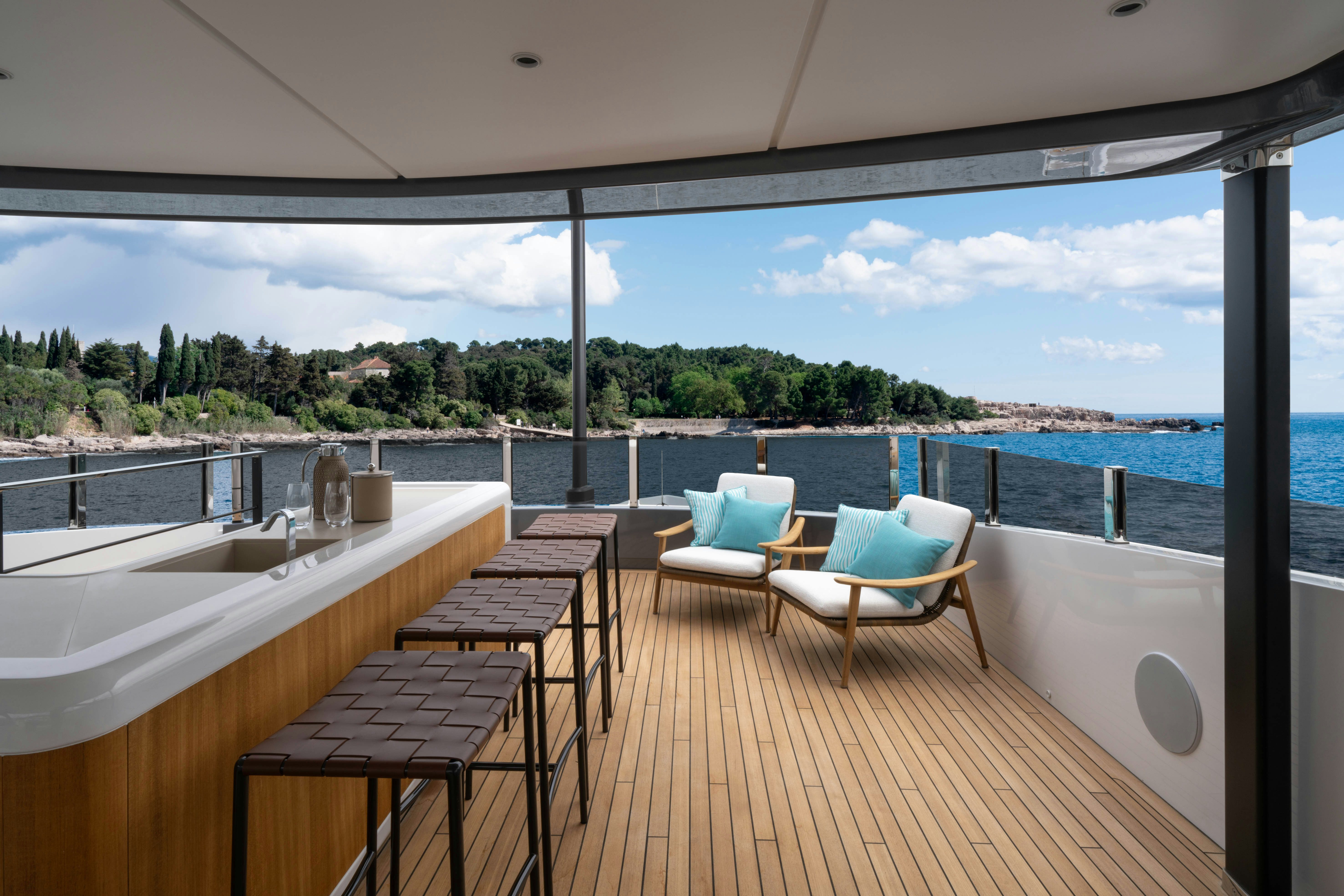 a room with a table and chairs on a deck overlooking a body of water aboard CANOE CANOE Yacht for Charter