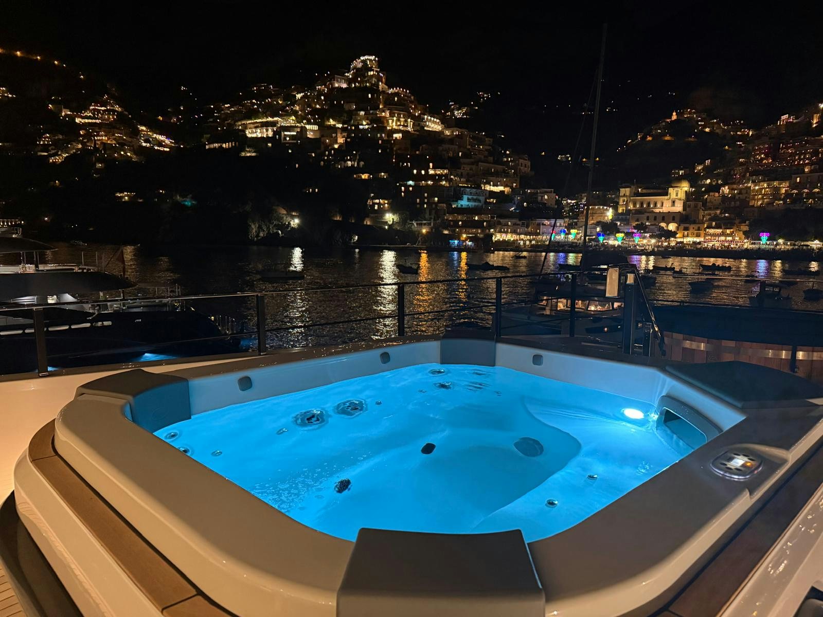 a pool on a balcony overlooking a city at night aboard CANOE CANOE Yacht for Charter