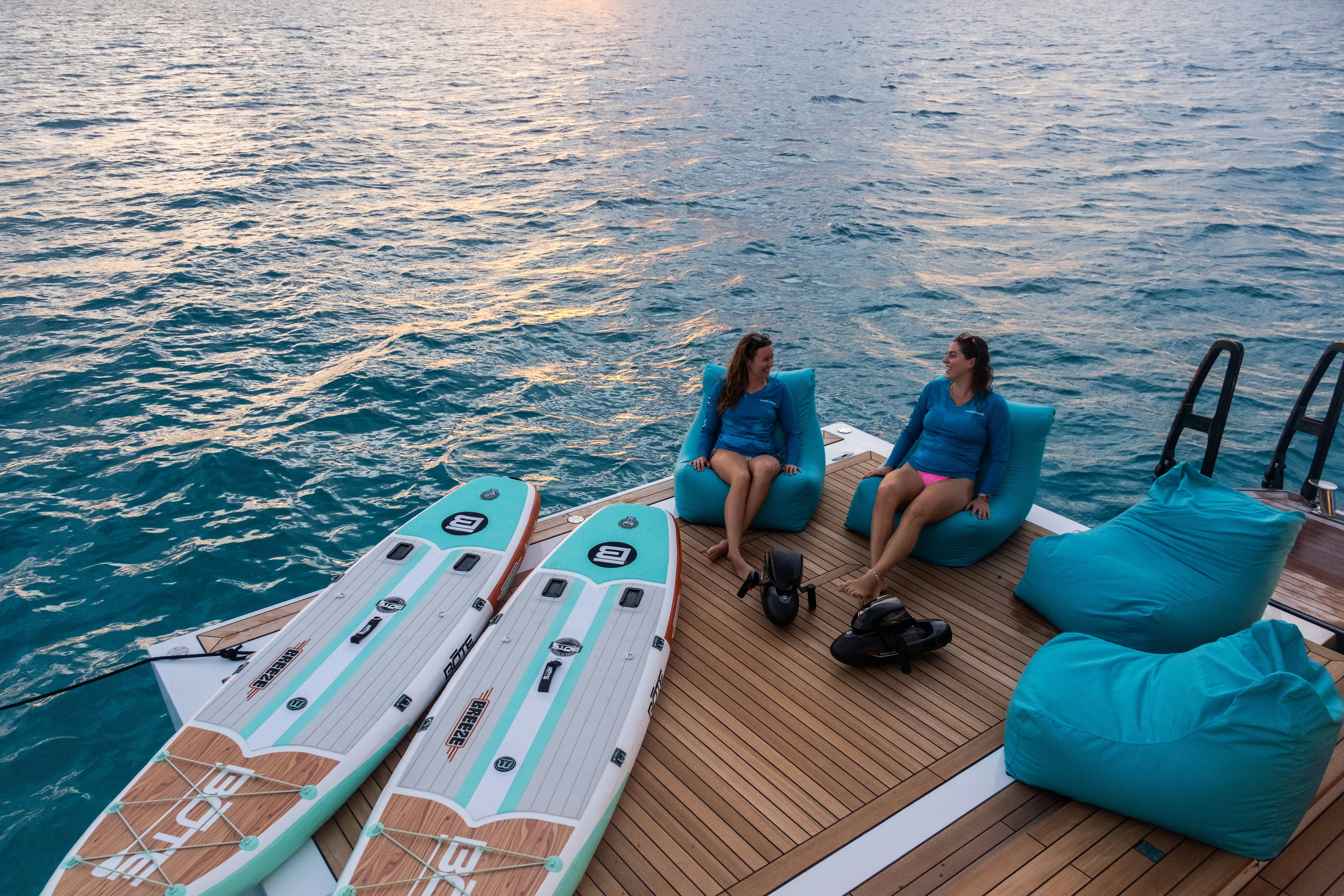 a couple of women sitting on a dock on a boat aboard CANOE CANOE Yacht for Charter
