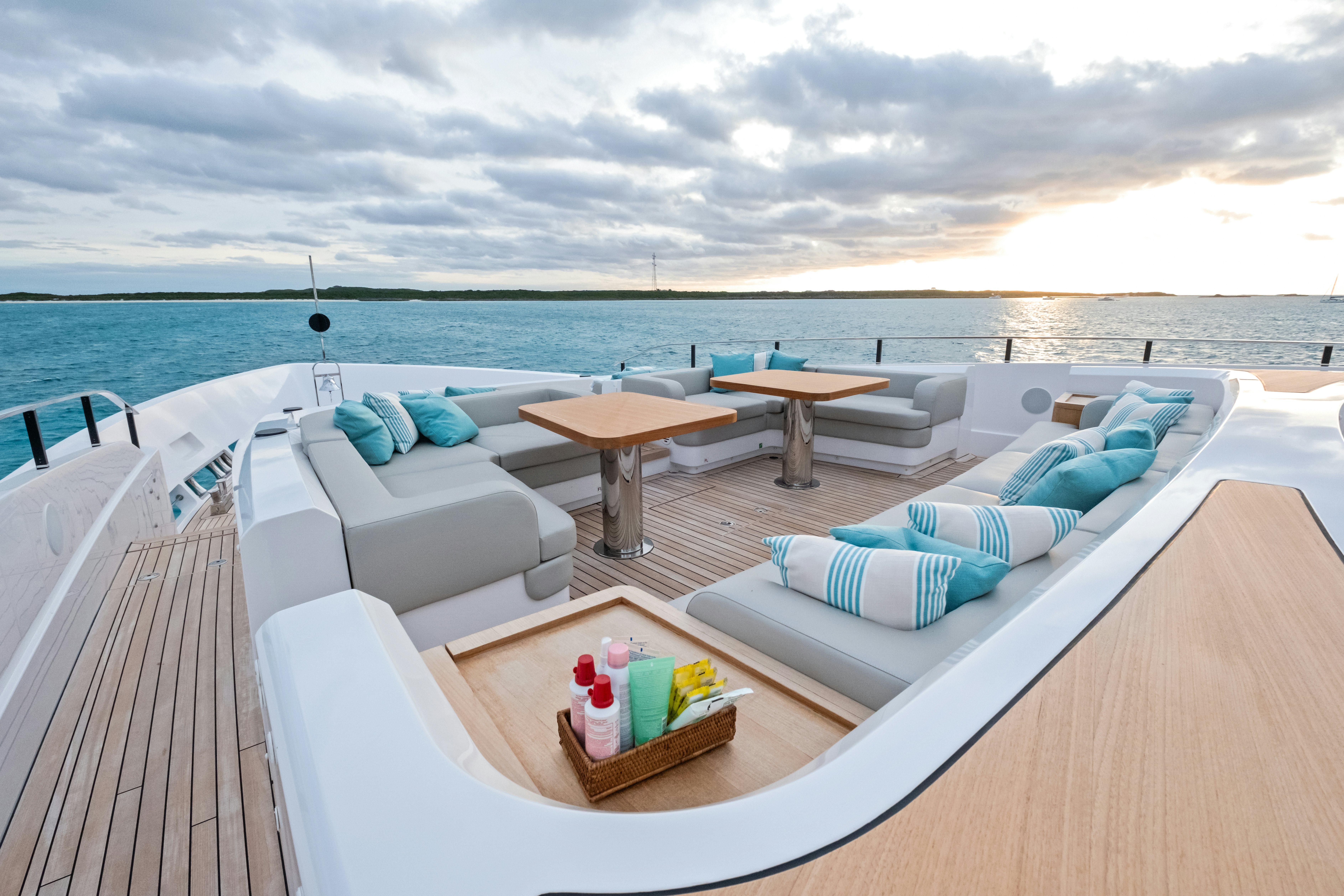 a balcony with a table and chairs and a pool with a view of the ocean aboard CANOE CANOE Yacht for Charter