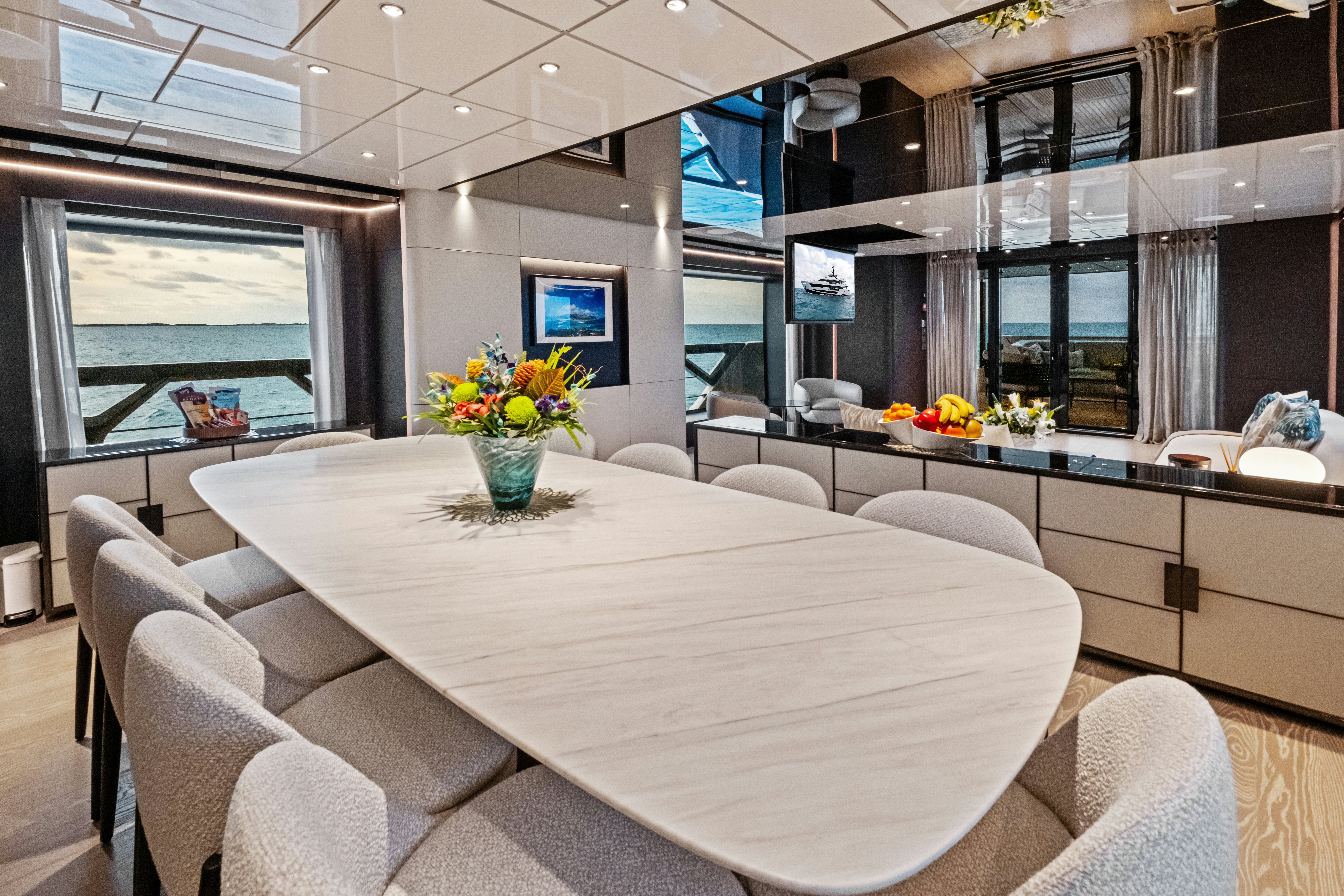 a room with a table chairs and a tv aboard CANOE CANOE Yacht for Charter