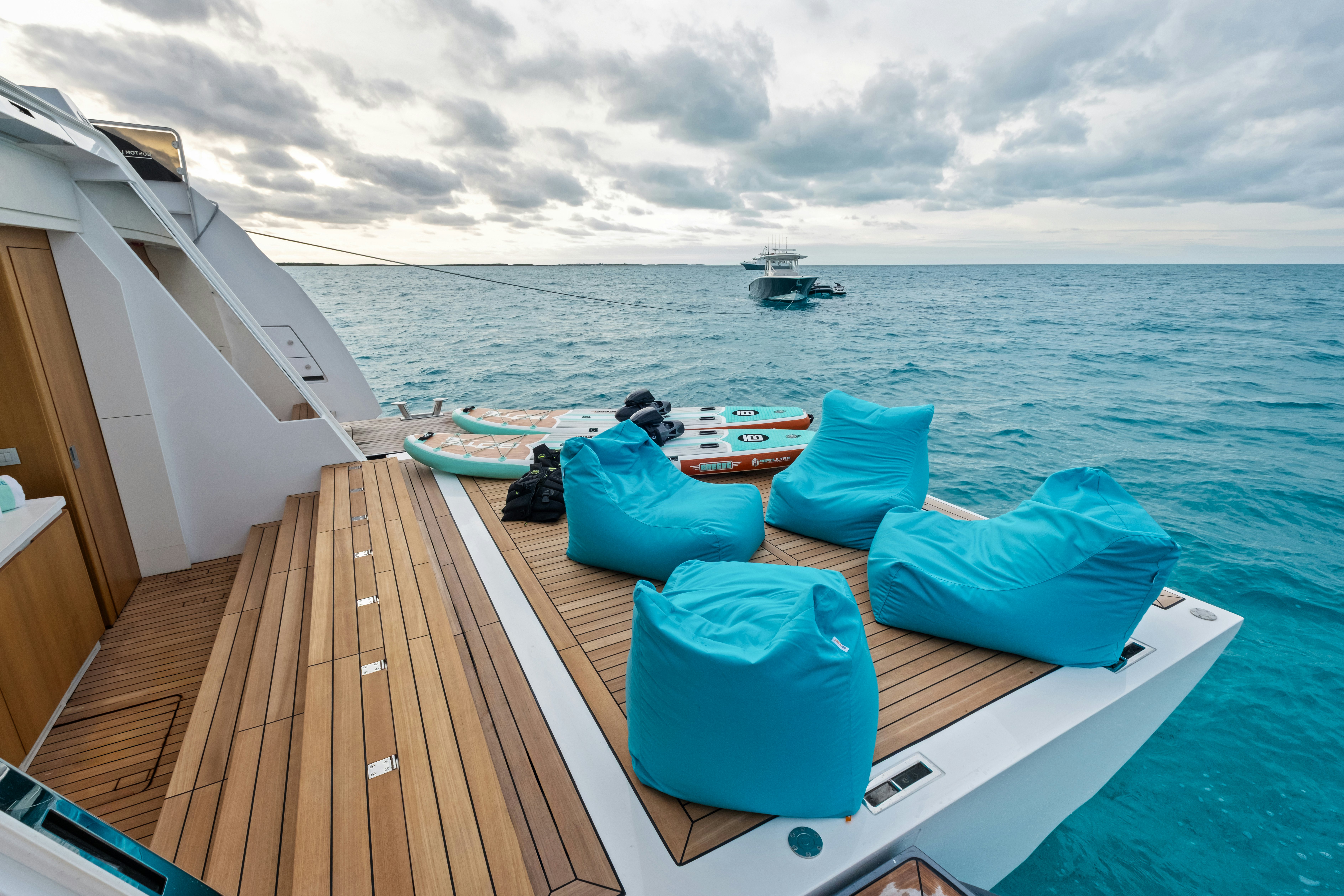 a deck with a boat and chairs on it aboard CANOE CANOE Yacht for Charter