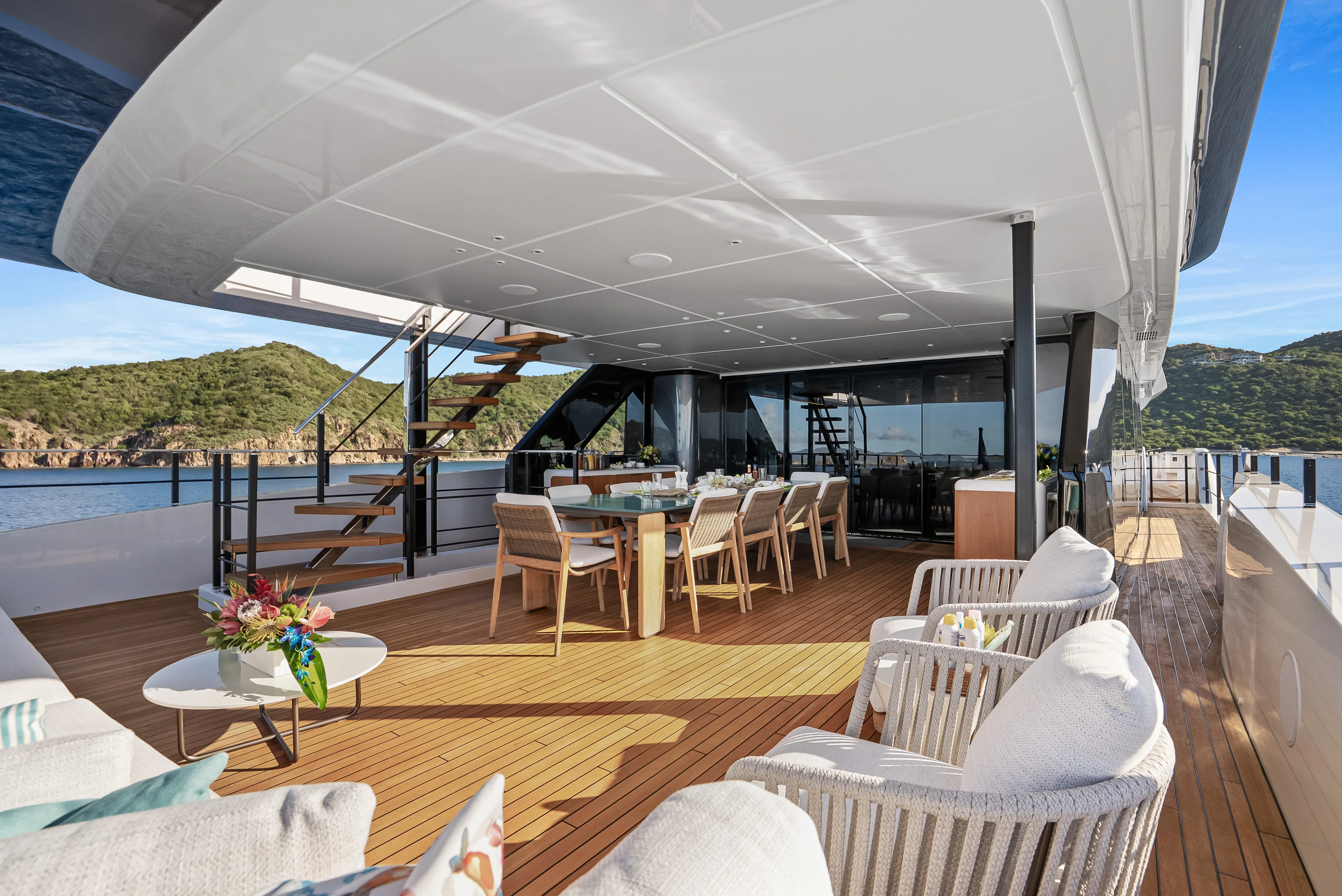 a large patio with a table and chairs and a large patio with a view of the water and aboard CANOE CANOE Yacht for Charter