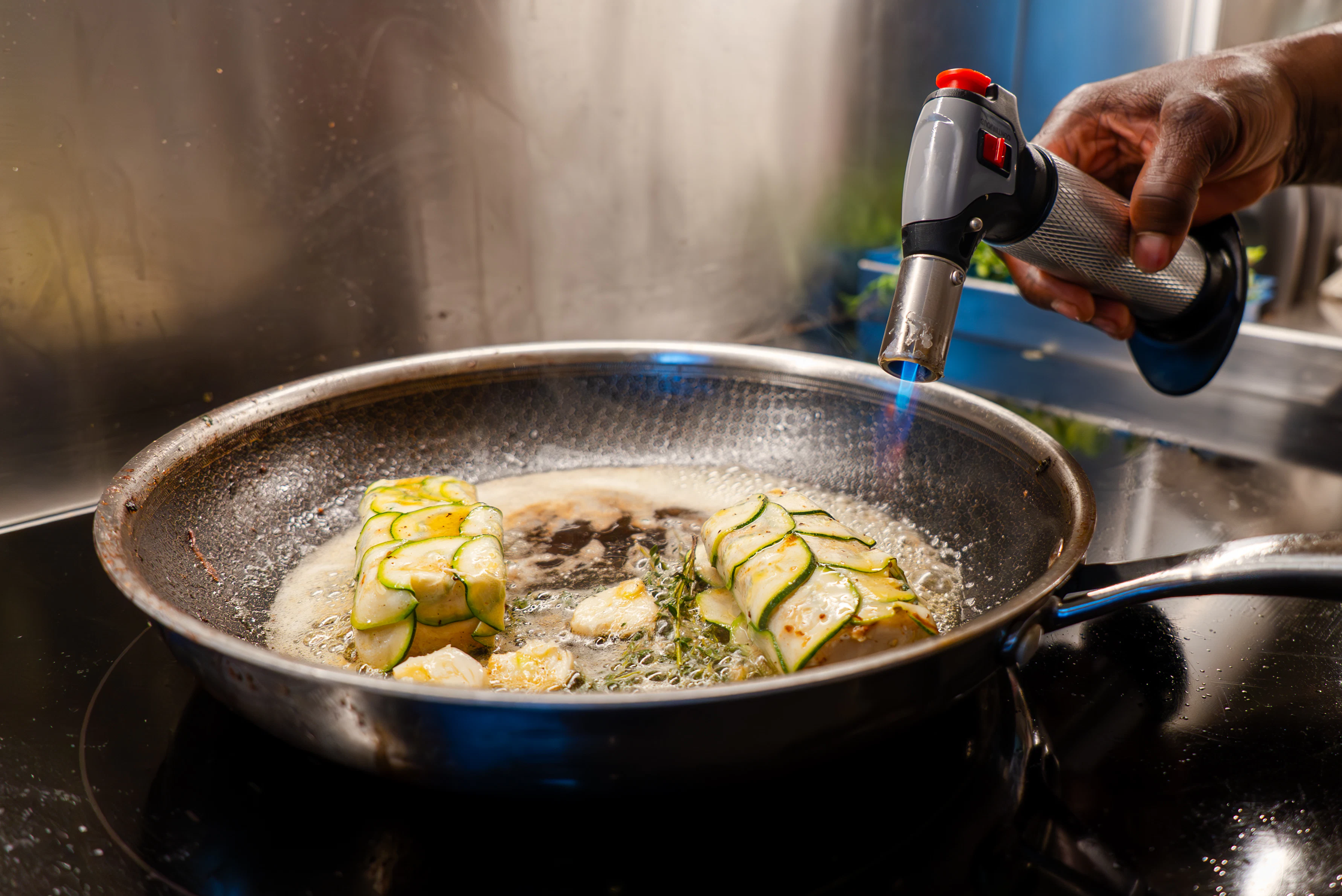 a person cooking food in a pan aboard CANOE CANOE Yacht for Charter