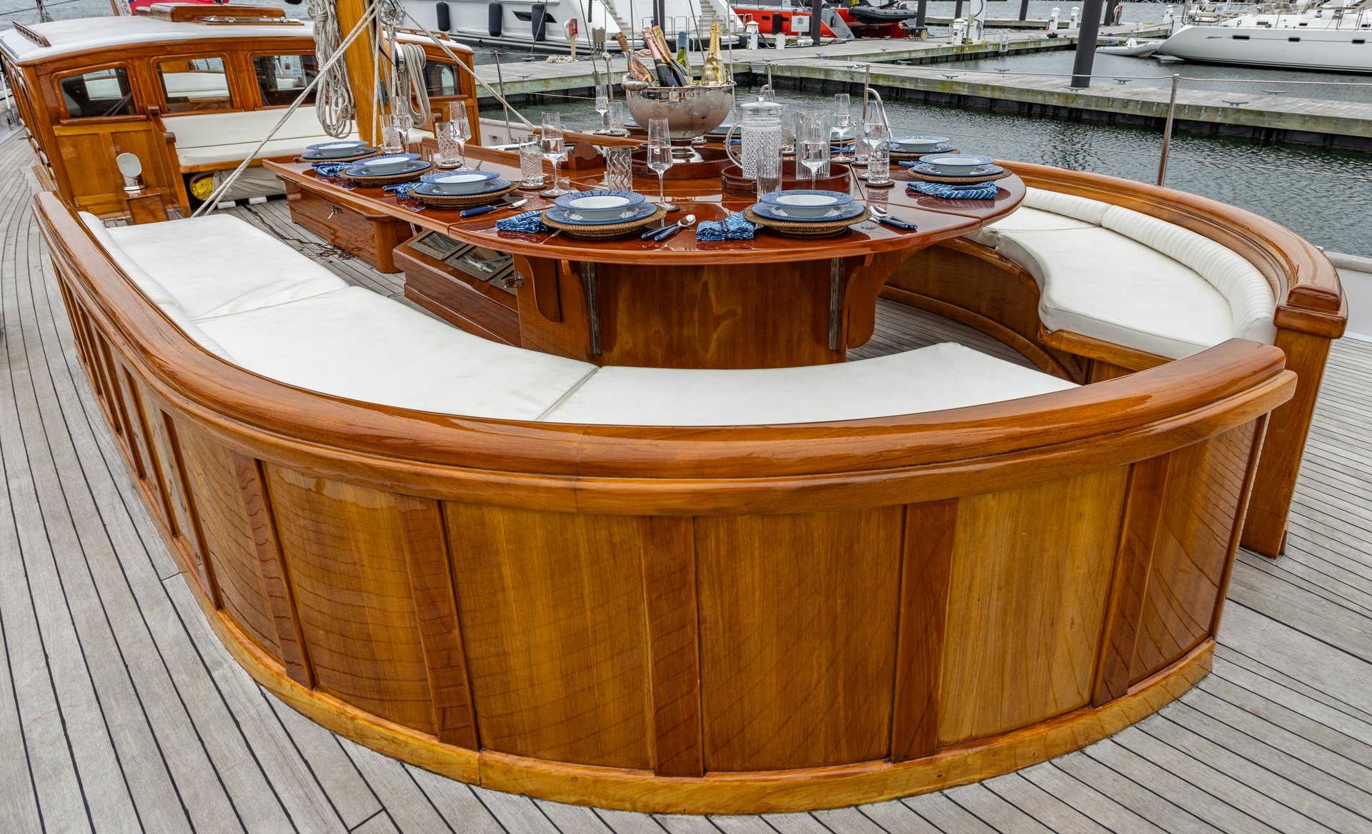 a wooden table with plates and glasses on it aboard HERMITAGE Yacht for Sale