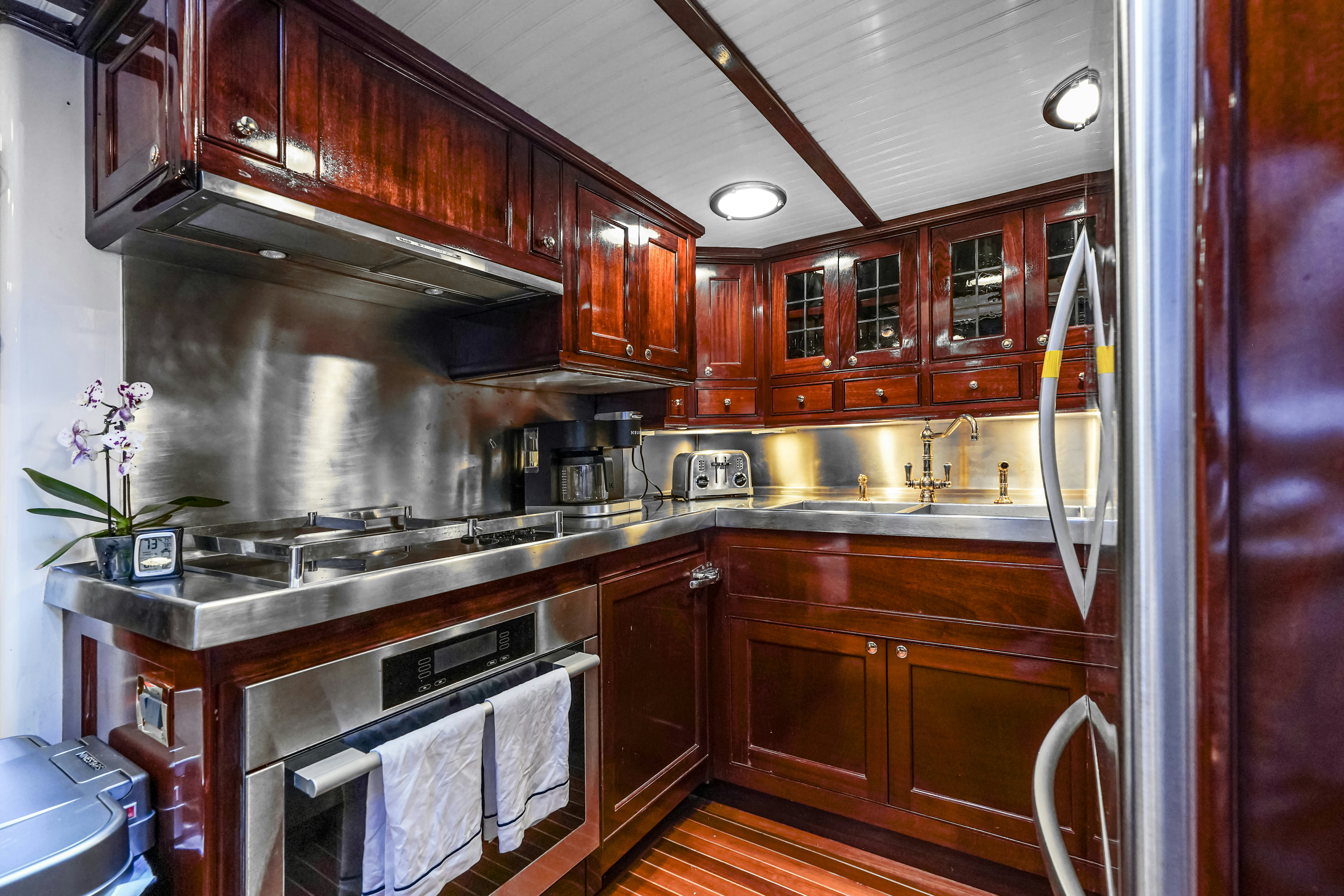 a kitchen with wooden cabinets aboard HERMITAGE Yacht for Sale