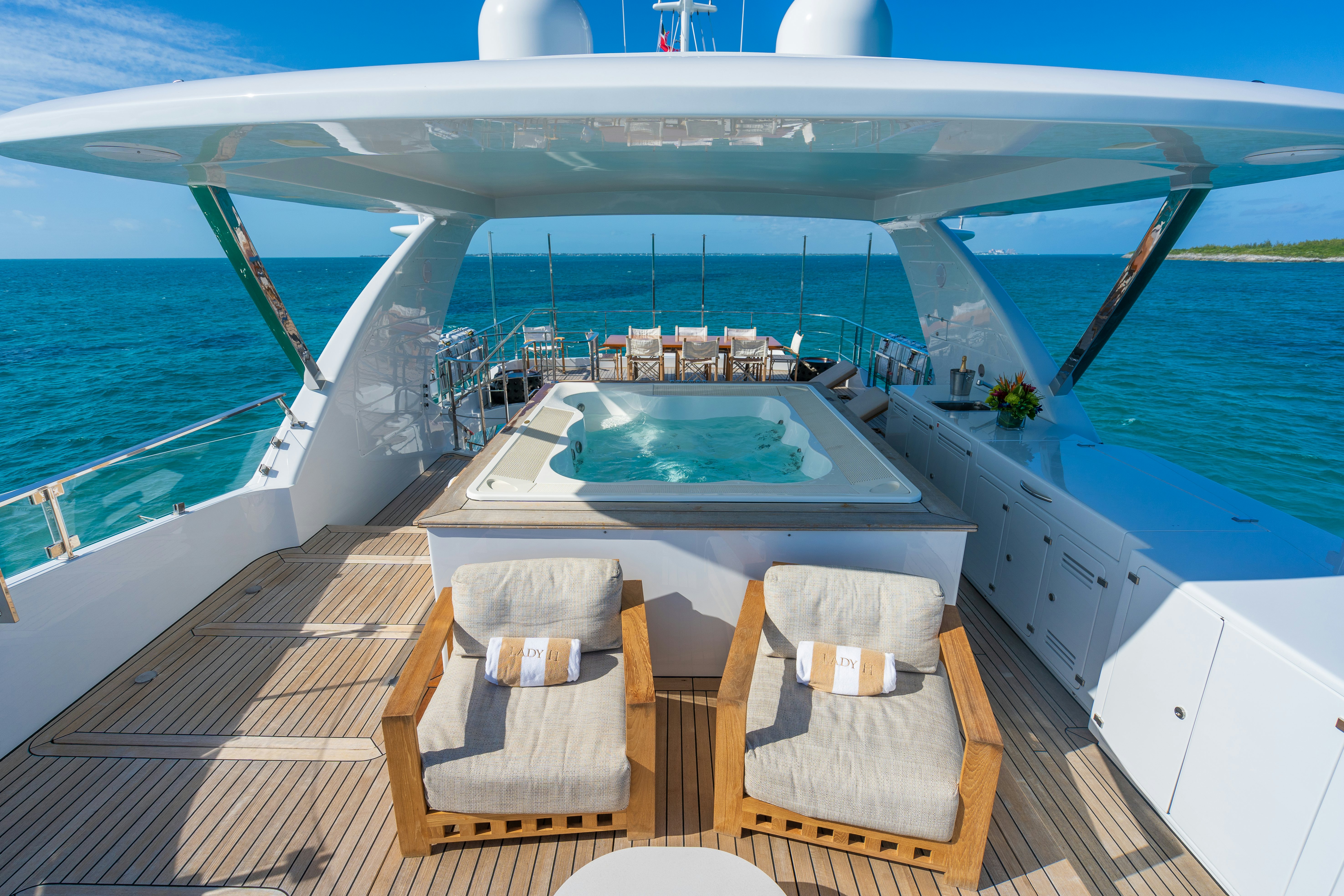 a deck with a chair and a table on it aboard LADY H Yacht for Charter