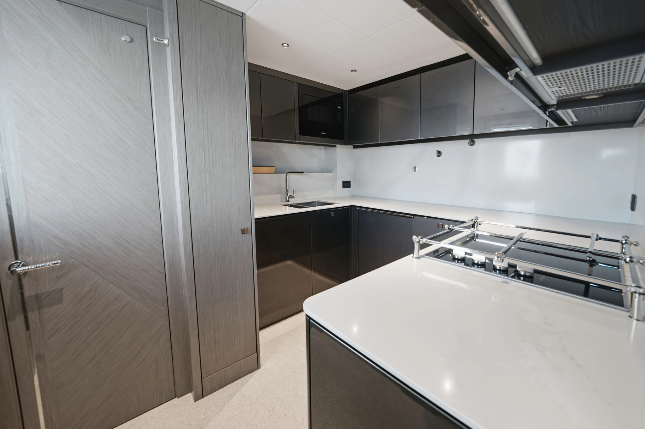 a kitchen with black cabinets aboard PURA VIDA Yacht for Sale