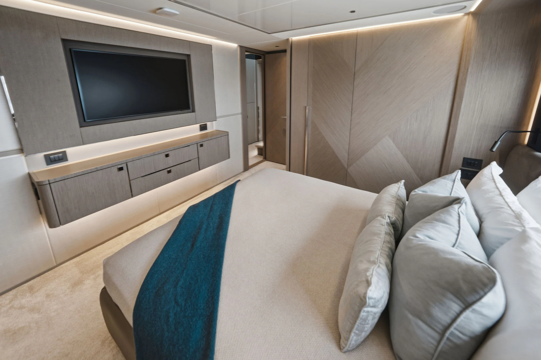 a bed with a white pillow and a television on it aboard PURA VIDA Yacht for Sale