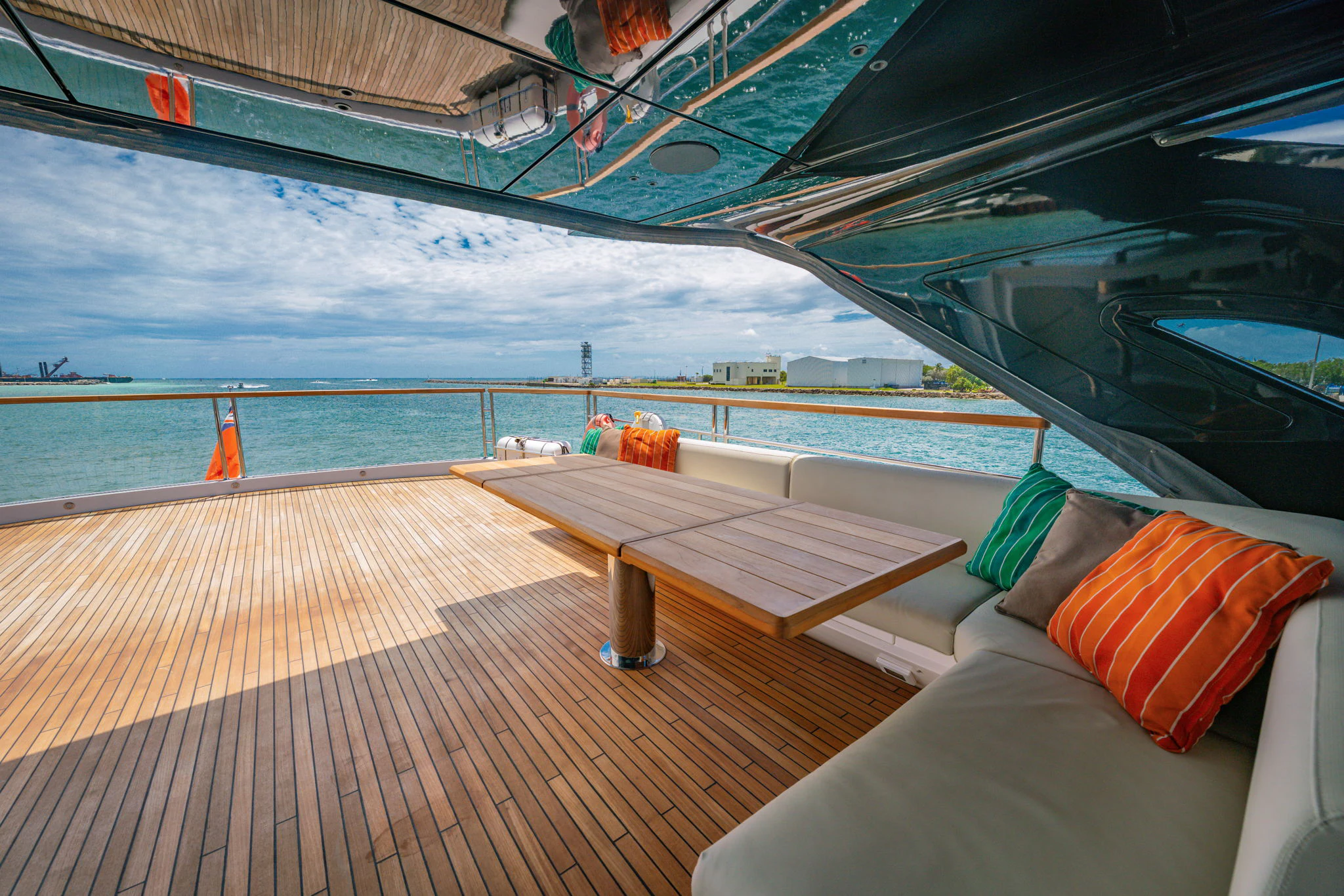 a deck with a view of the ocean and a boat aboard PURA VIDA Yacht for Sale