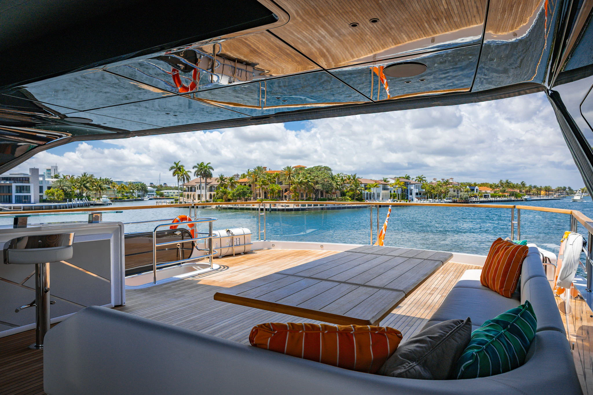 a deck with a pool and a beach and trees aboard PURA VIDA Yacht for Sale