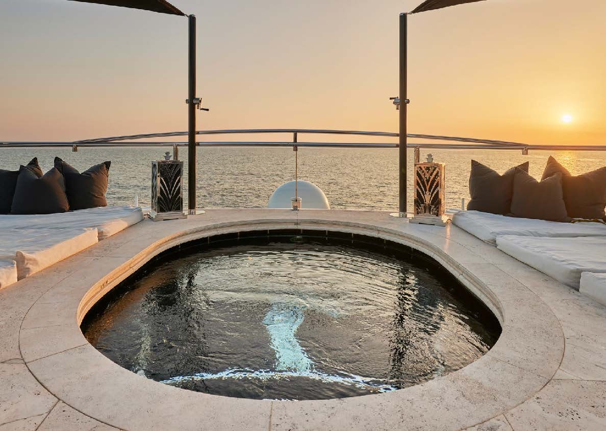 a large pool with a view of the ocean and a city in the background aboard SILVER ANGEL Yacht for Charter