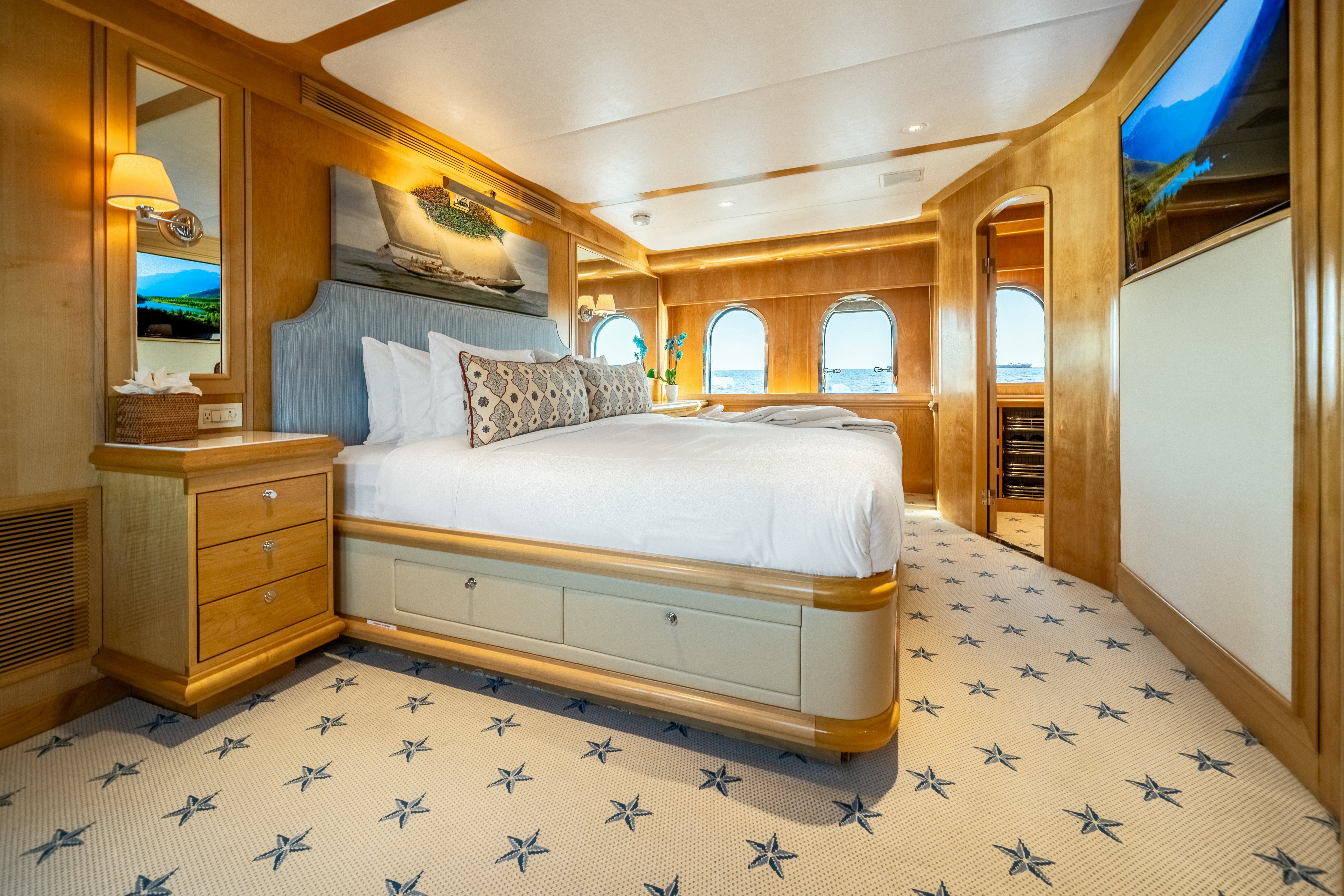 a bedroom with a bed and a television aboard DESTINATION Yacht for Sale