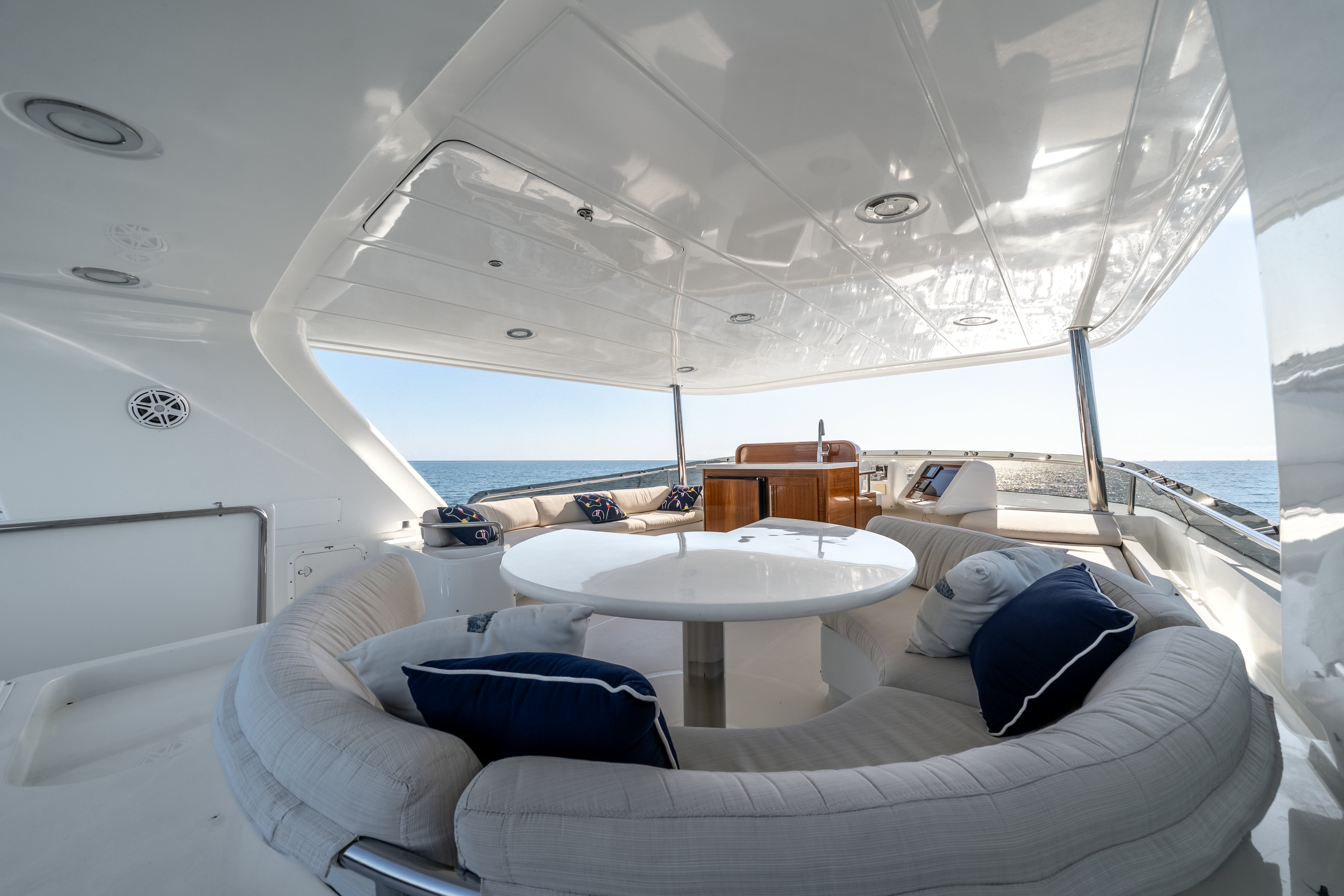 a room with a large white table and a white couch aboard DESTINATION Yacht for Sale