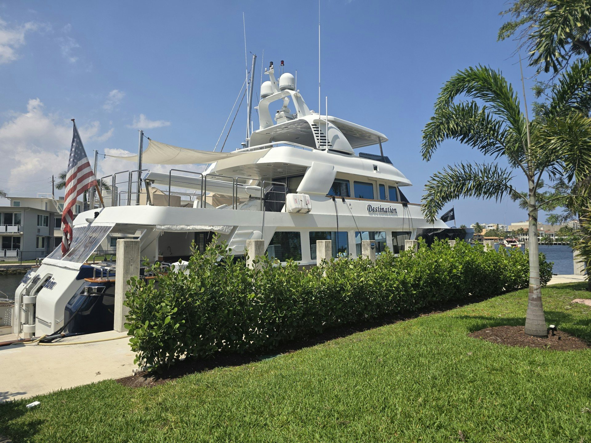 a white boat with a flag on it aboard DESTINATION Yacht for Sale