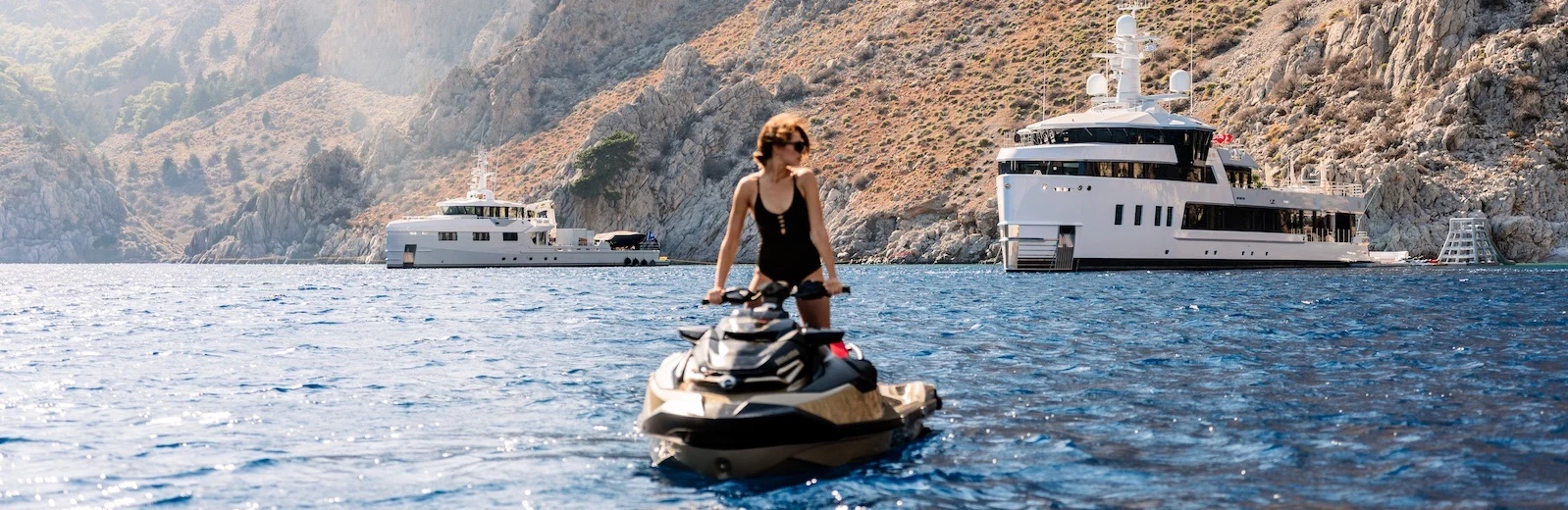 a man on a boat in the water with a boat in the background aboard AFTER YOU Yacht for Charter