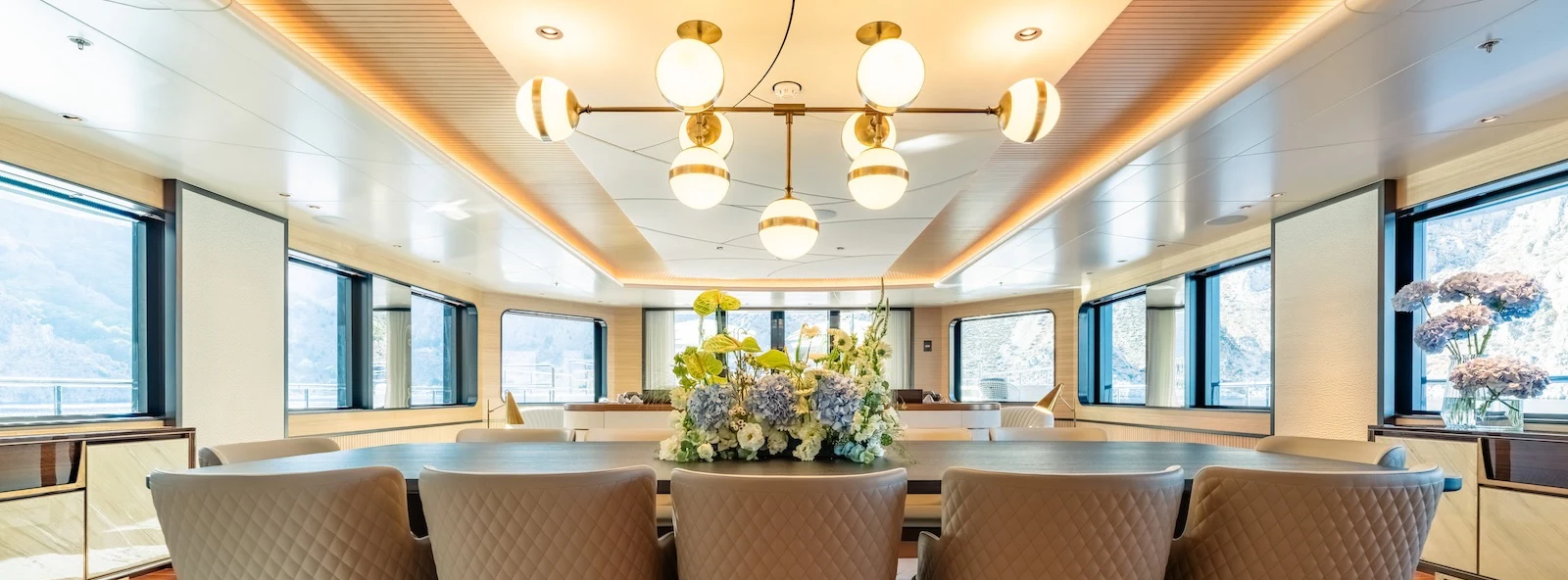 a room with couches and a table with a plant on it aboard AFTER YOU Yacht for Charter
