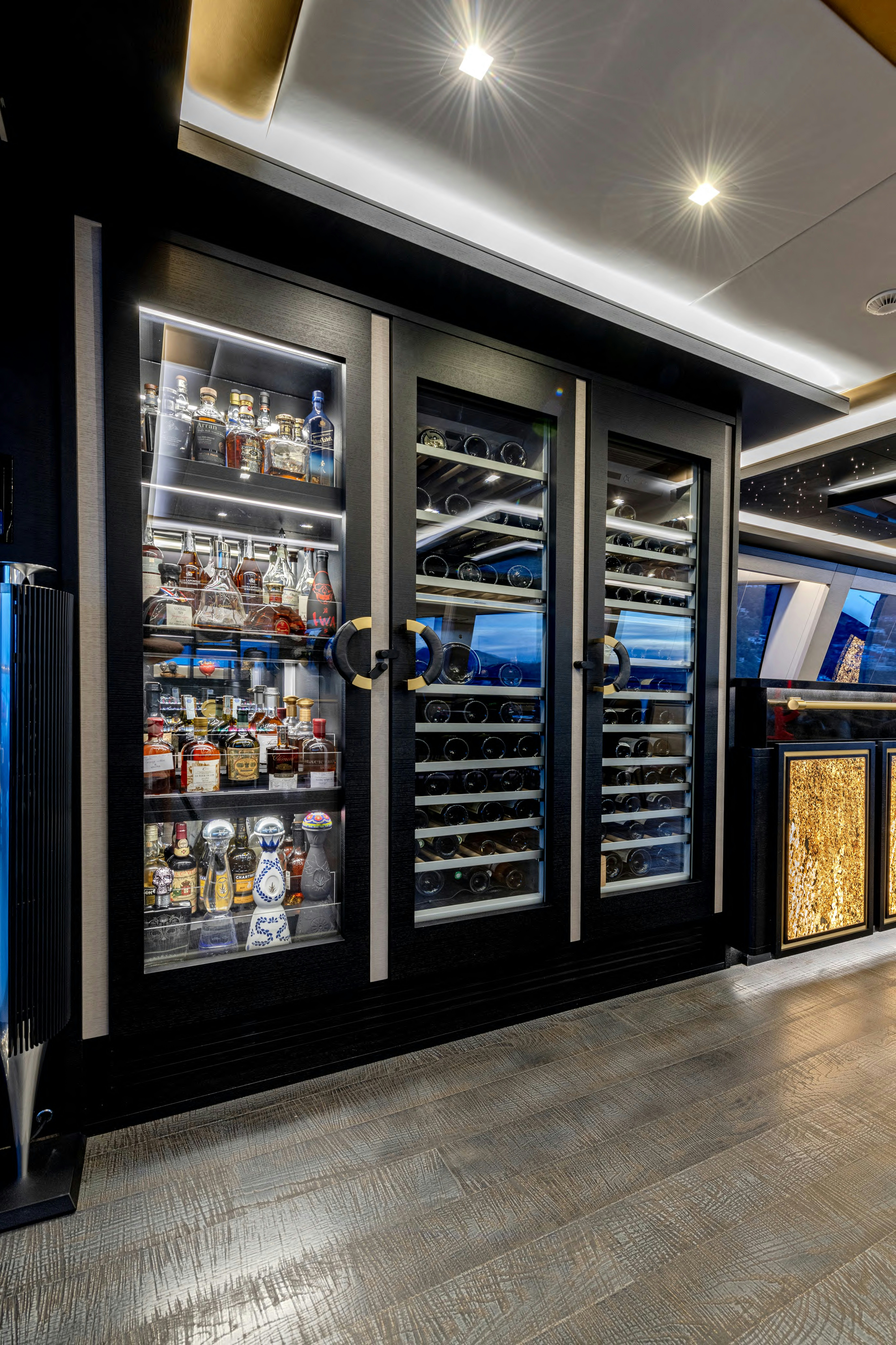 a large room with a glass display case and a lot of bottles aboard BLACK LEGEND Yacht for Sale