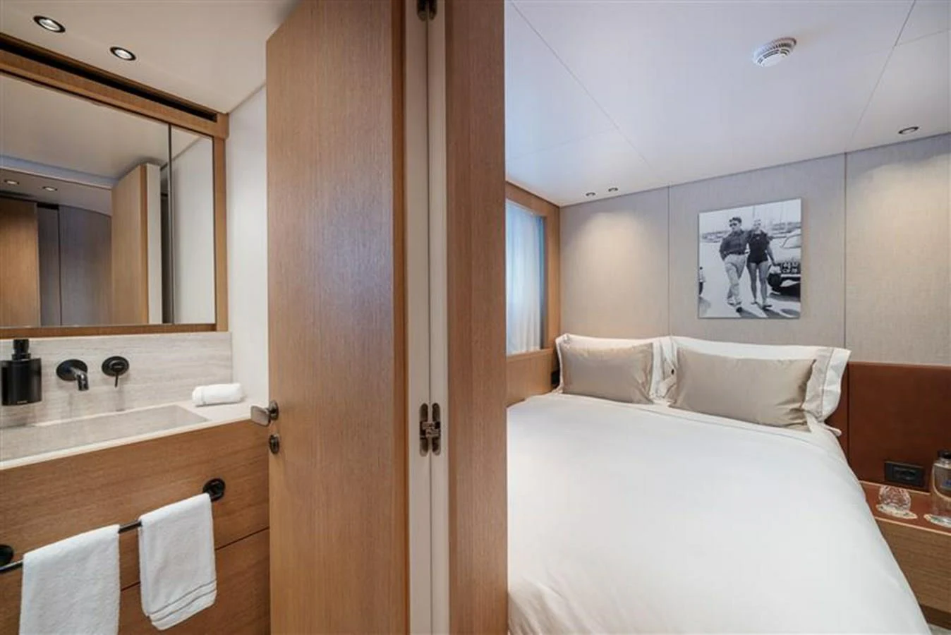a bedroom with a bed and a mirror aboard INVICTUS Yacht for Sale