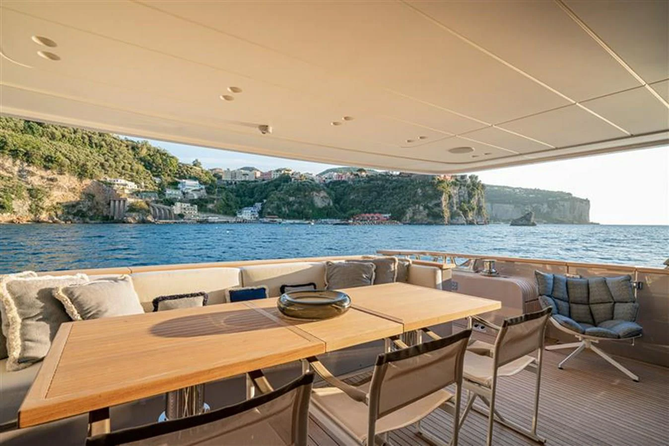 a table and chairs on a deck overlooking a body of water aboard INVICTUS Yacht for Sale