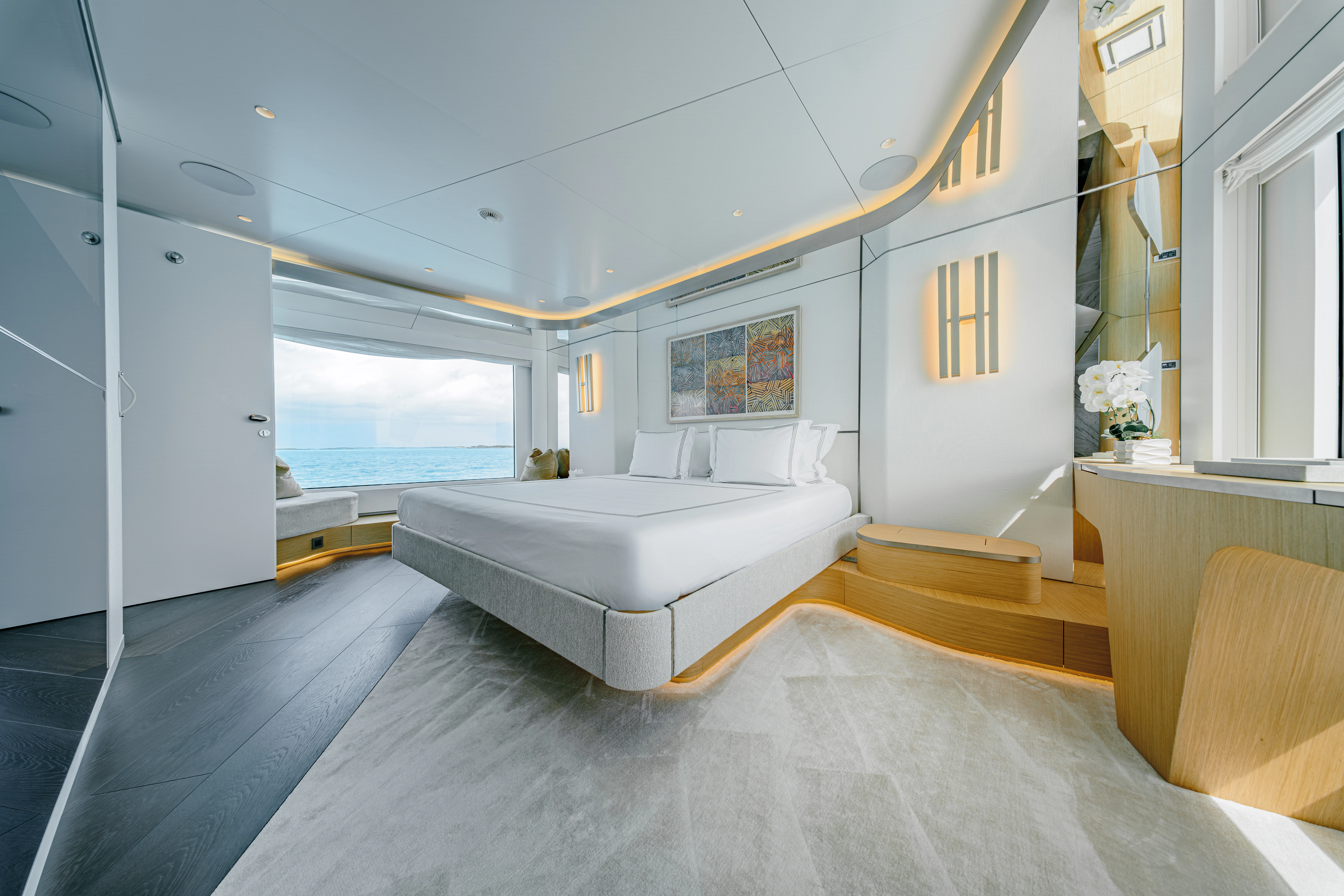a room with a bed and a large window aboard PROPOSITION Yacht for Charter