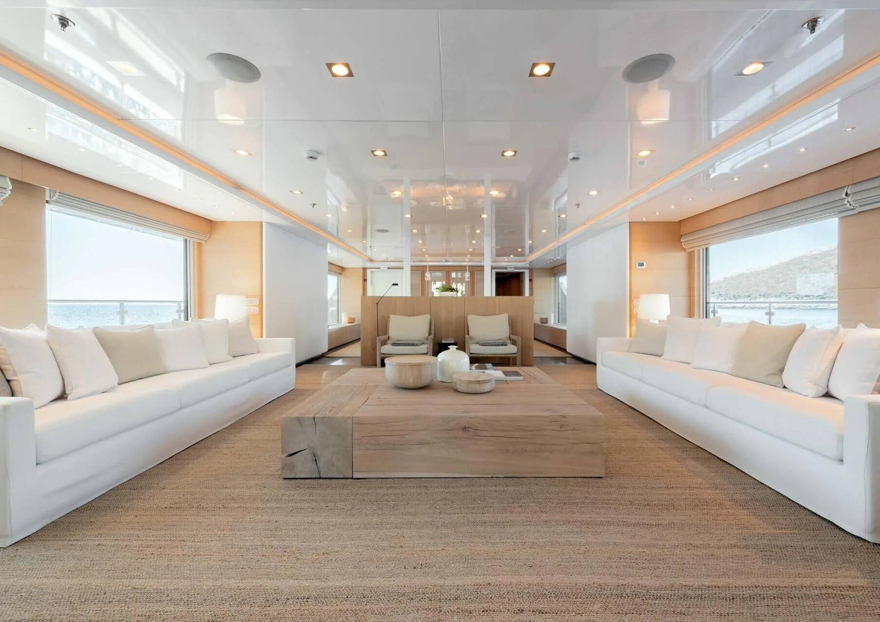 a large living room with white couches and a large window aboard ZIA Yacht for Charter
