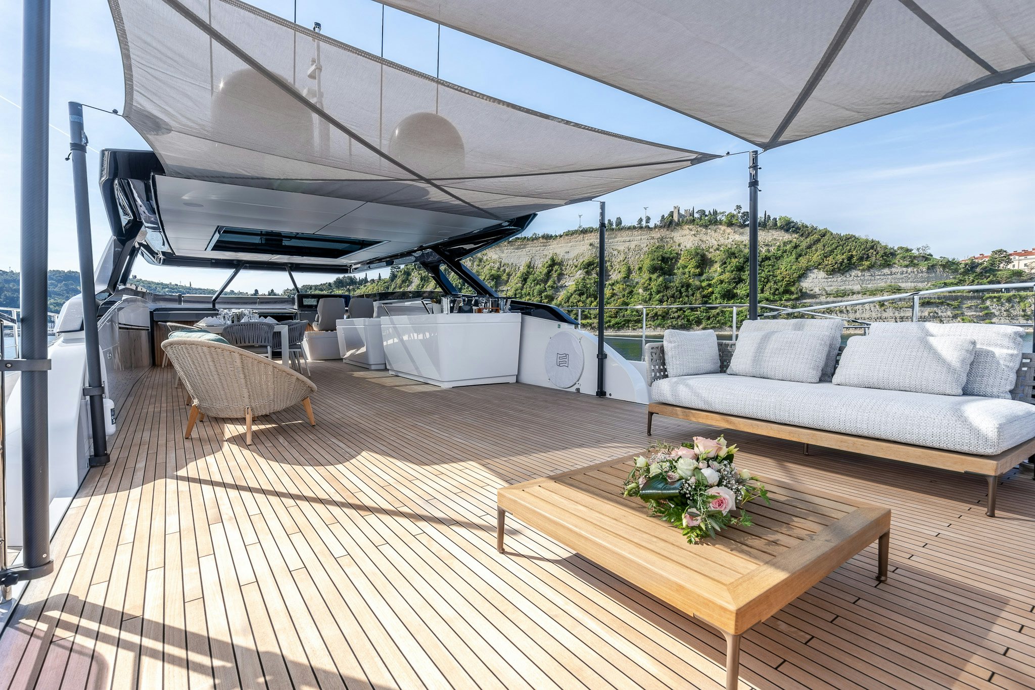 a deck with a table and couches on it aboard ISOTTA Yacht for Sale