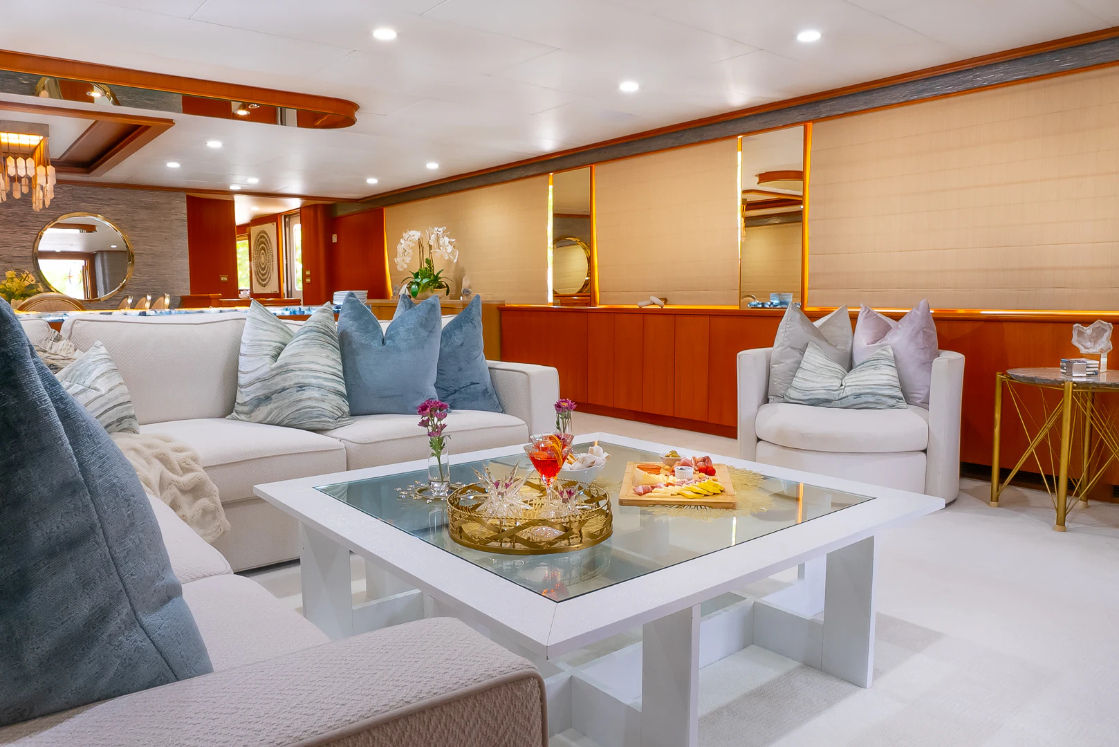 a living room with a white couch and a round table with food on it aboard GALE WINDS Yacht for Charter