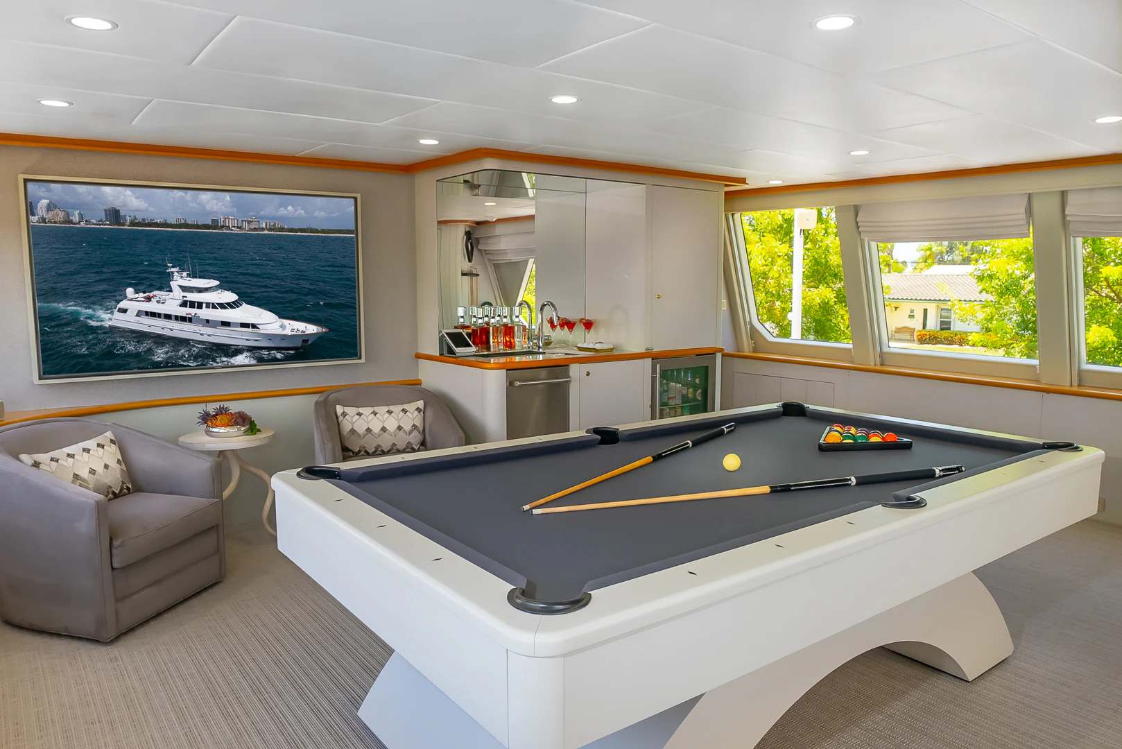 a large living room with a large pool table and couches aboard GALE WINDS Yacht for Charter