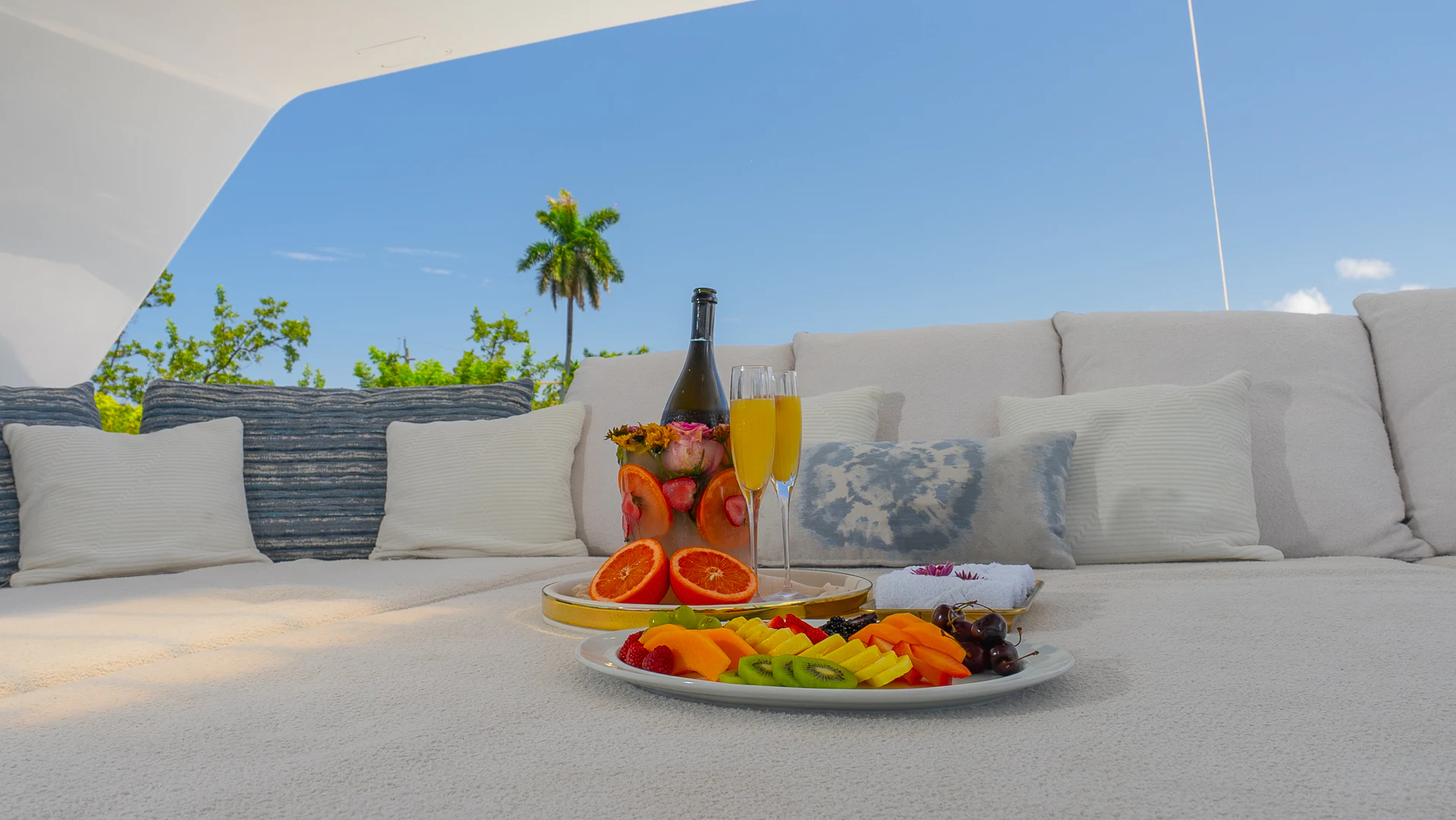 a white couch with a glass of wine and a tray of food on it aboard GALE WINDS Yacht for Charter