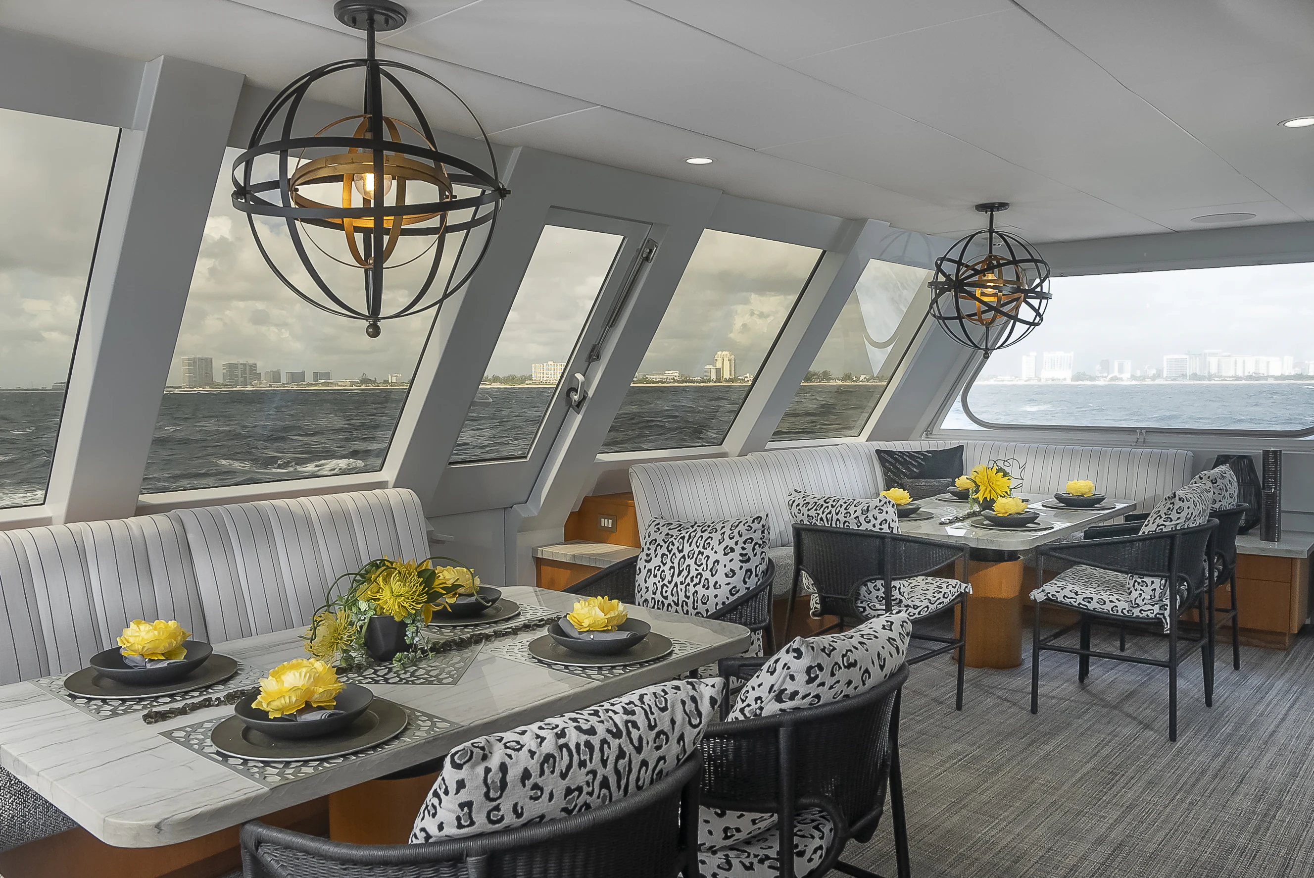 a room with a table chairs and a chandelier aboard GALE WINDS Yacht for Charter