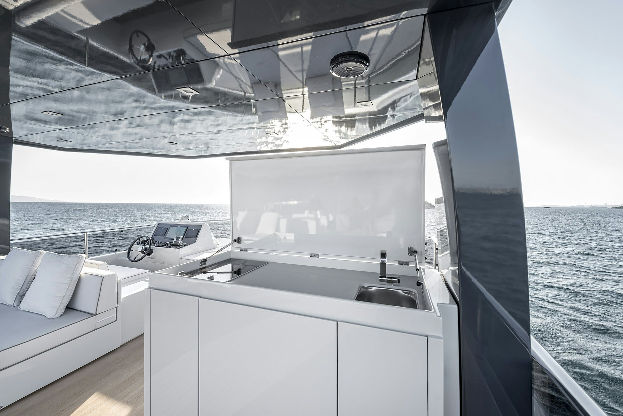 a white kitchen with a sink and a bed aboard IGUAZU Yacht for Sale