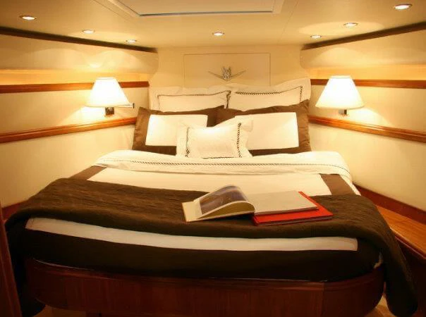 a bed with a book on it aboard ISAKINDOFMAGIC Yacht for Sale
