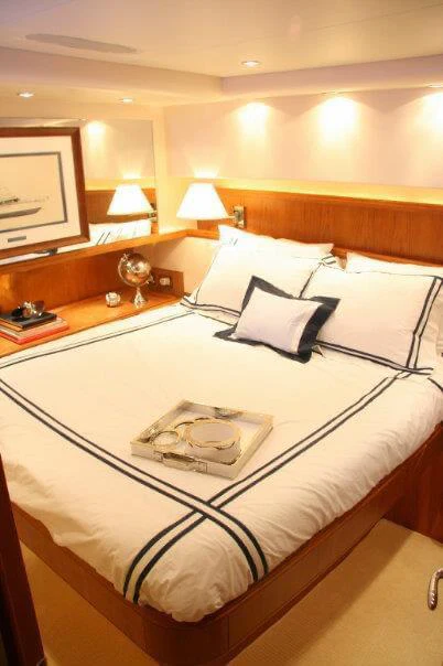a bed with a white comforter and pillows aboard ISAKINDOFMAGIC Yacht for Sale