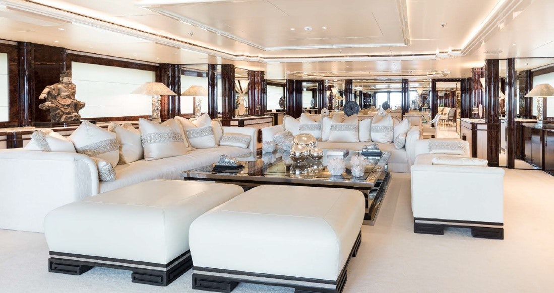 a large living room with white couches and a large window aboard LIONESS V Yacht for Sale