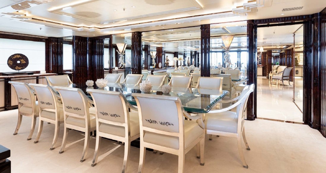 a room with tables and chairs aboard LIONESS V Yacht for Sale
