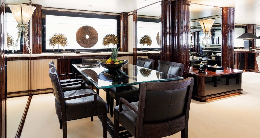 a room with a table chairs and a large window aboard LIONESS V Yacht for Sale