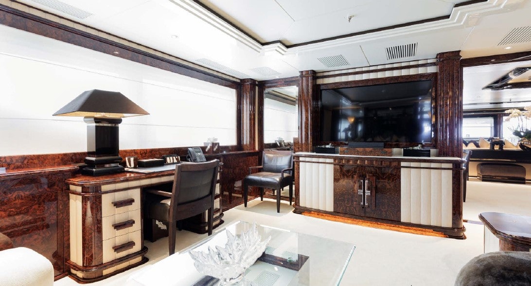 a room with a piano and a table and chairs aboard LIONESS V Yacht for Sale