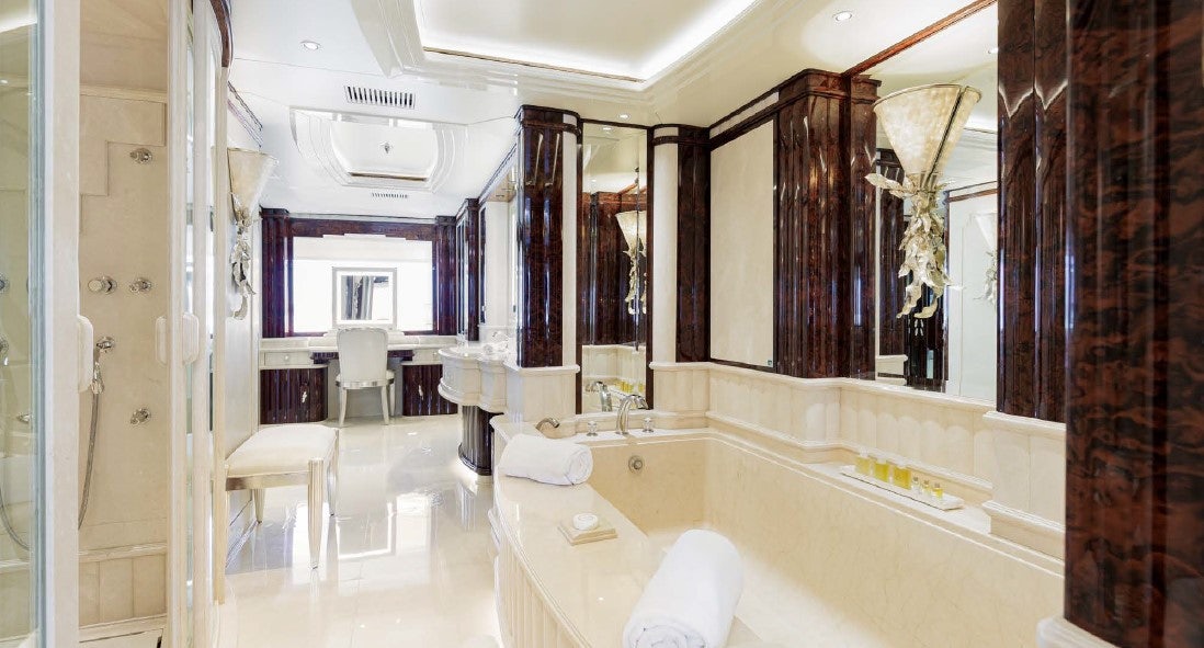 a bathroom with a bathtub and sinks aboard LIONESS V Yacht for Sale