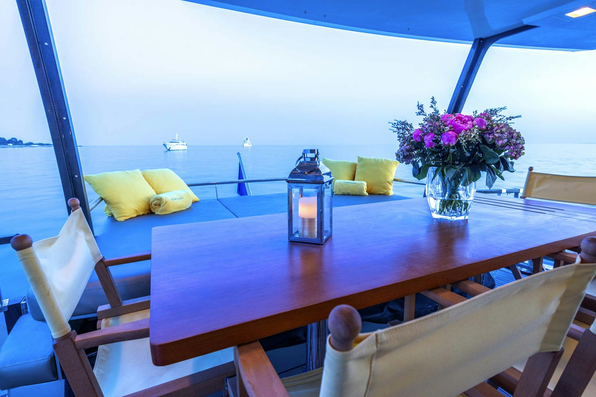 a table with chairs and a vase of flowers on it aboard QUANTUM Yacht for Charter